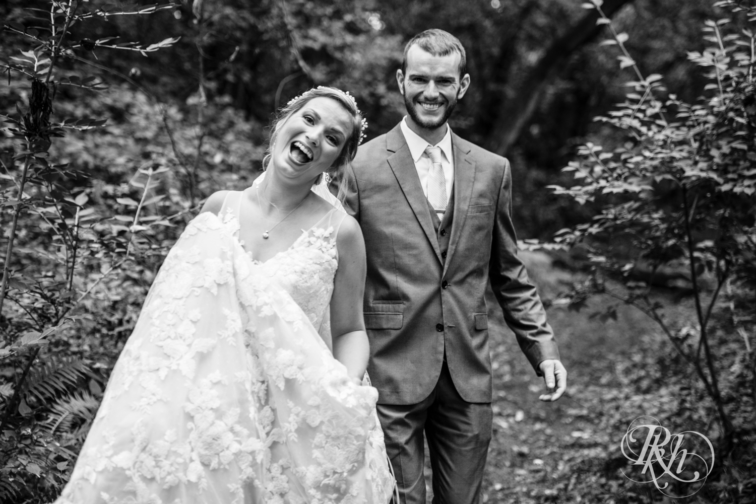 Bride and groom smile on rainy day at Camrose Hill in Stillwater, Minnesota.