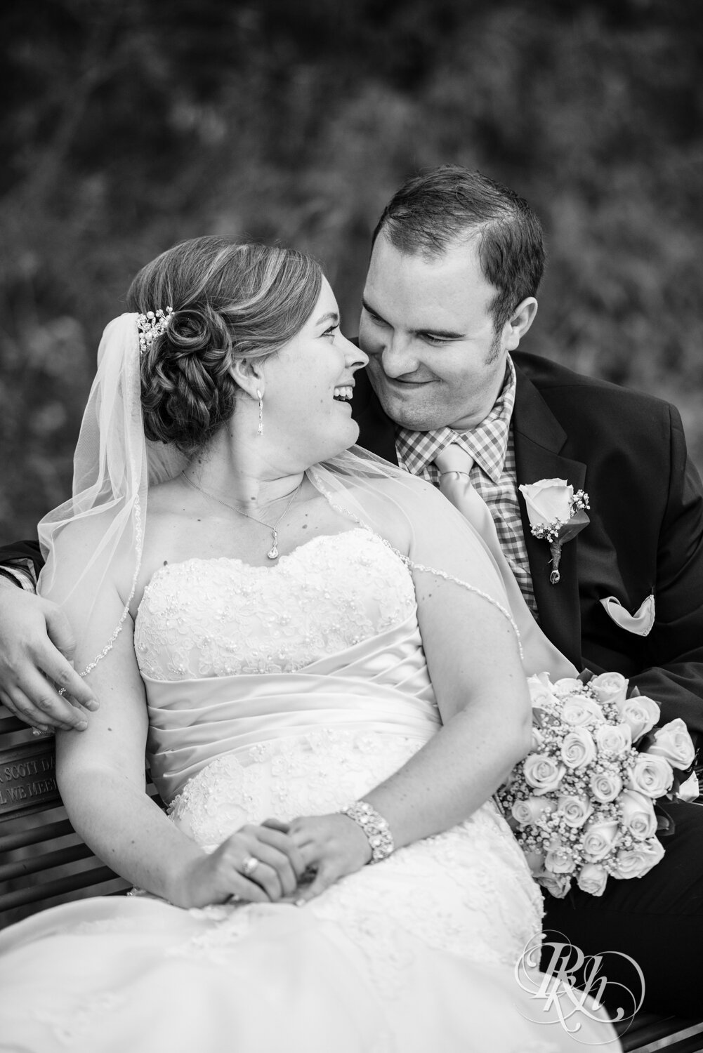 Bride and groom smile by wildflowers at Eagan Community Center in Eagan, Minnesota.