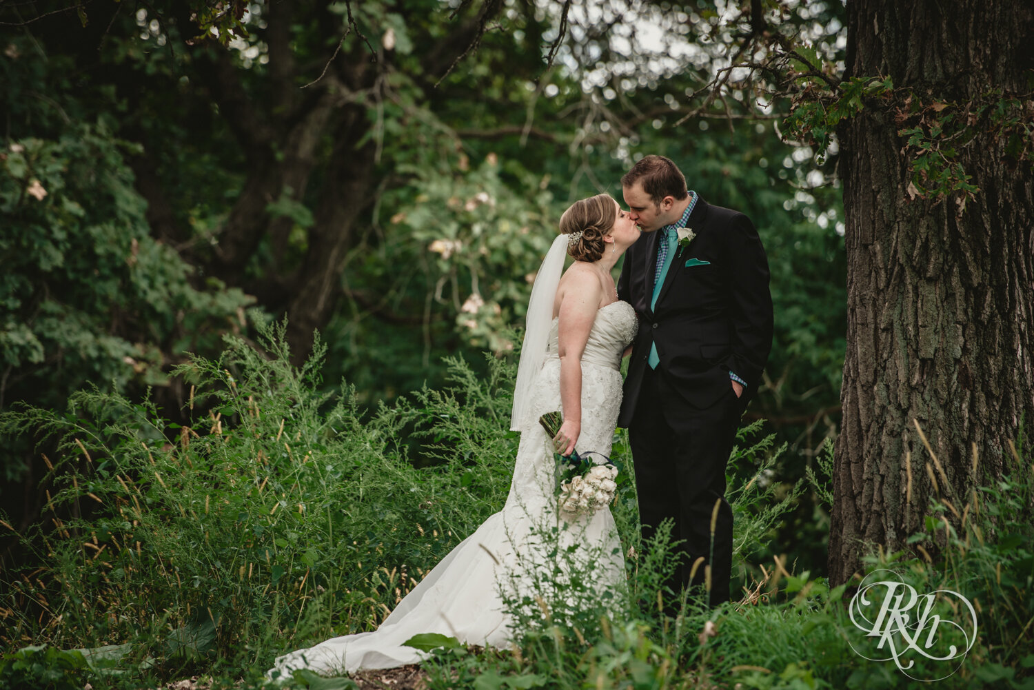 Bride and groom kiss in the trees at Eagan Community Center in Eagan, Minnesota.