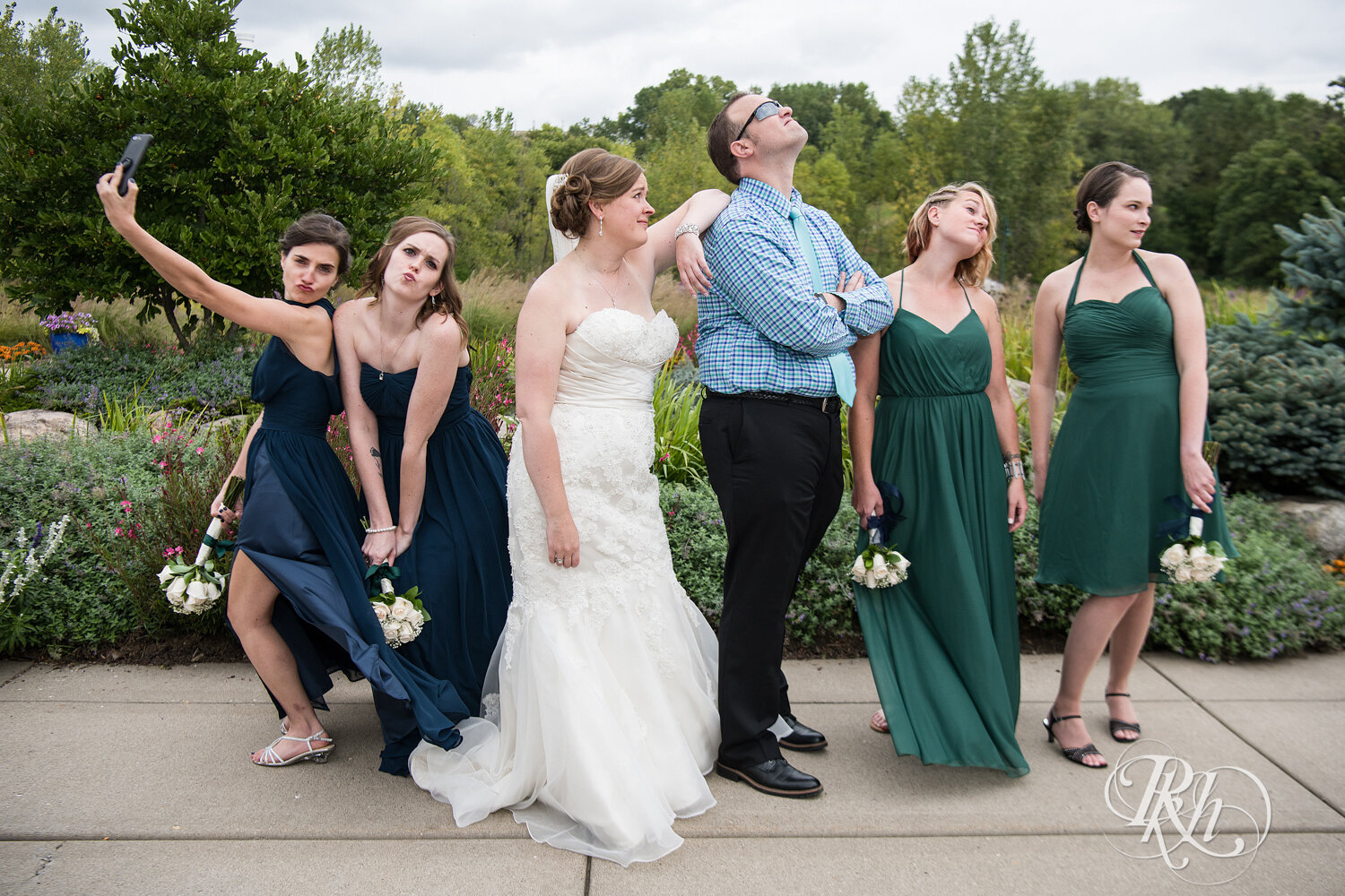 Wedding party in blue and green dresses laugh at Eagan Community Center in Eagan, Minnesota.