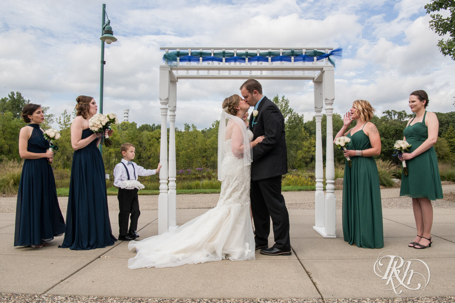 Bride and groom kiss at outdoor wedding ceremony at Eagan Community Center in Eagan, Minnesota.