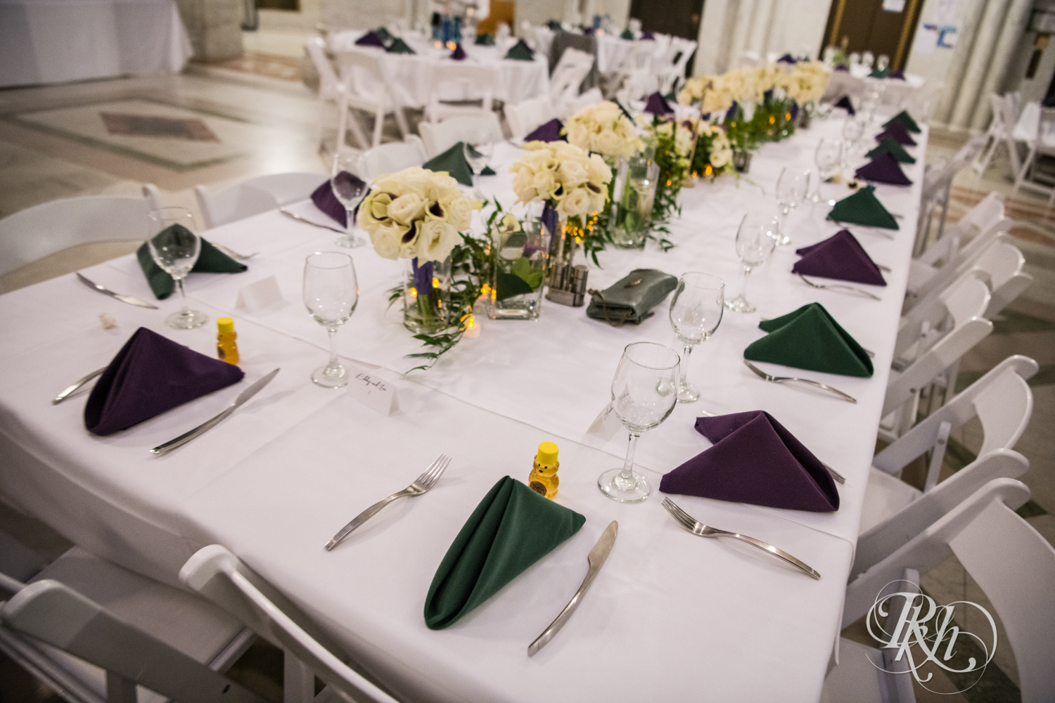 Wedding reception table with purple and green napkins in Minneapolis City Hall in Minneapolis, Minnesota.