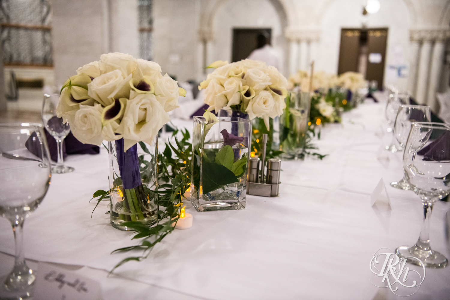 Wedding reception table with purple and green napkins in Minneapolis City Hall in Minneapolis, Minnesota.