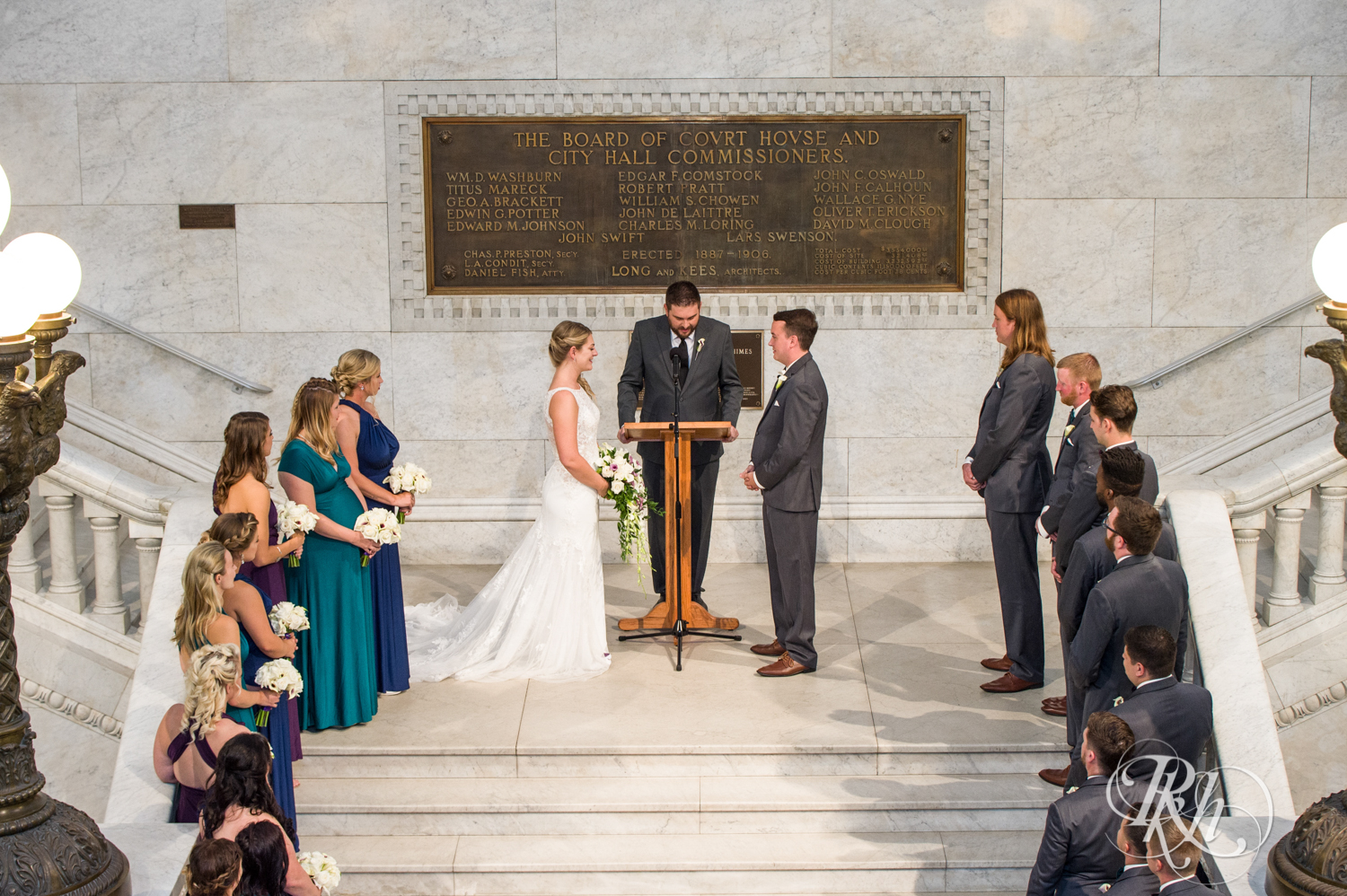 Bride and groom have ceremony on stairs at Minneapolis City Hall in Minneapolis, Minnesota.