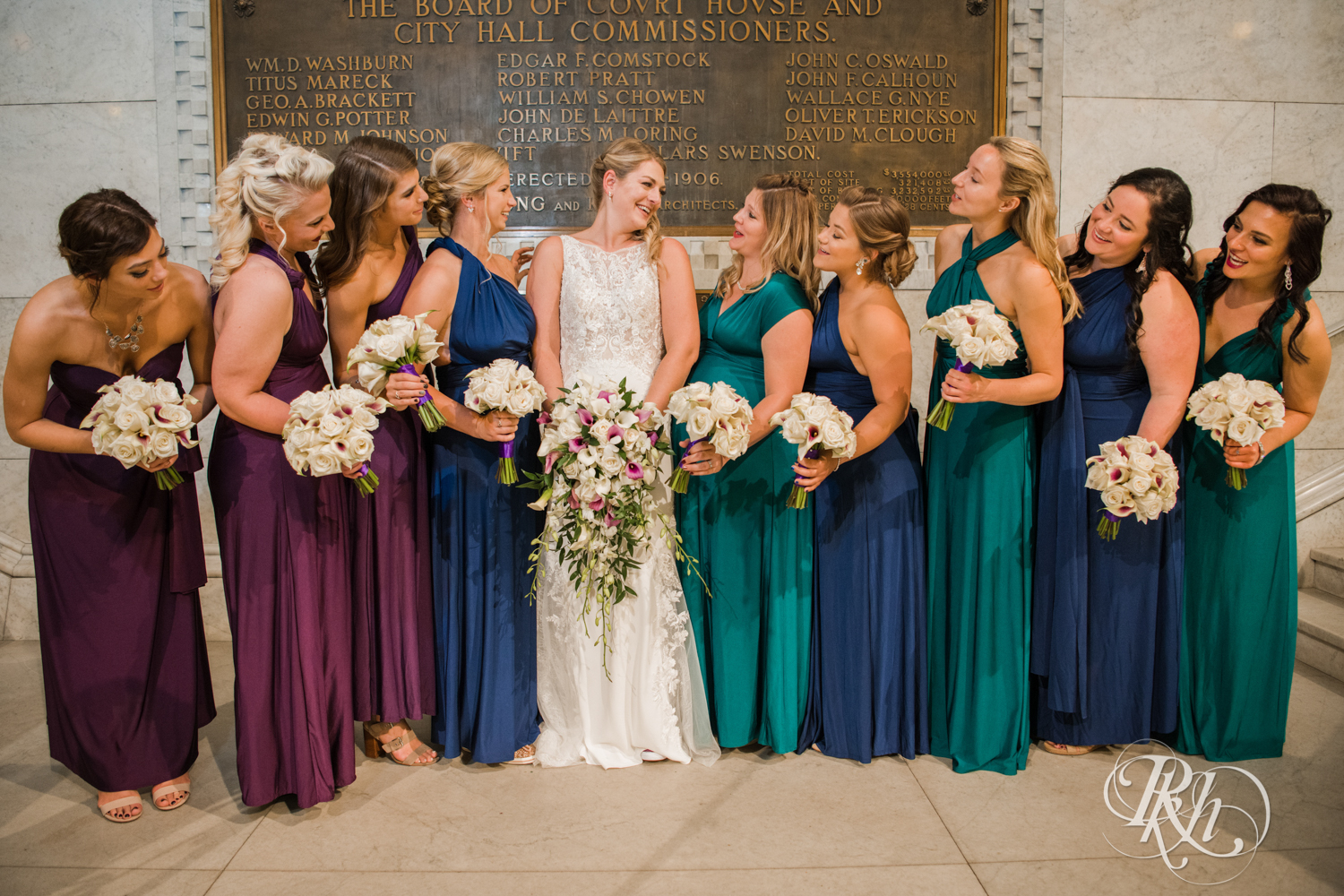 Wedding party in different color dresses at Minneapolis City Hall in Minneapolis, Minnesota.