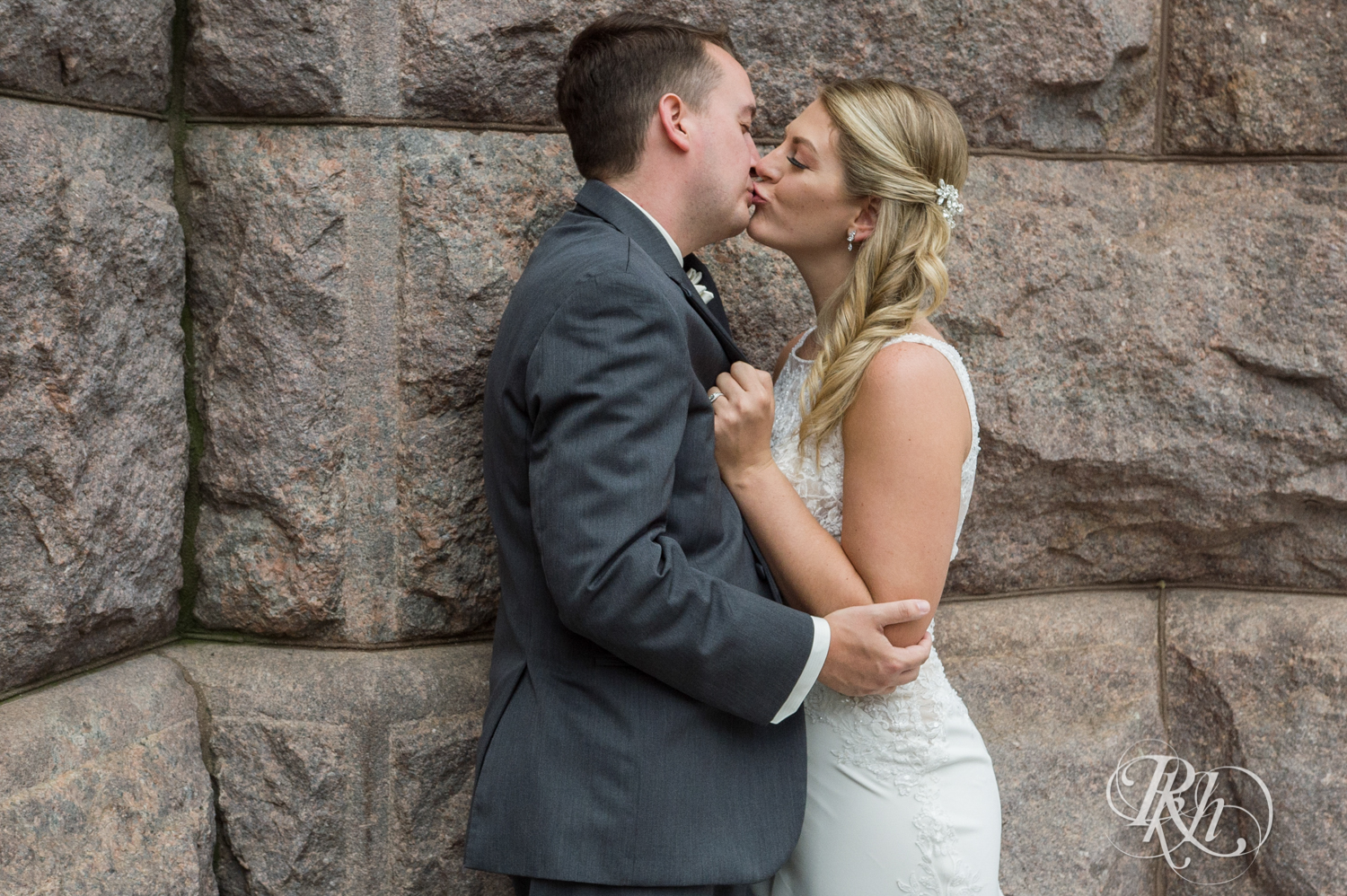 Bride and groom kiss in front of building in the city in Minneapolis, Minnesota.