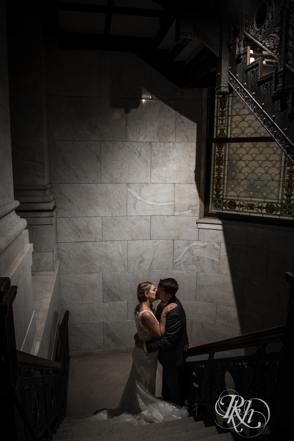 Bride and groom kiss in Minneapolis City Hall in Minneapolis, Minnesota.