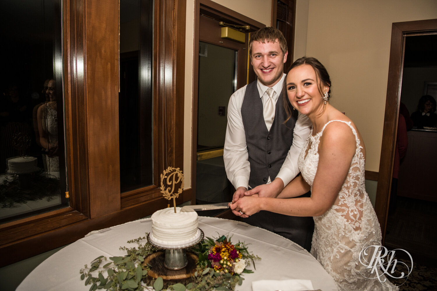 Bride and groom cut cake at wedding reception on rainy day at The Wilds Golf Club in Prior Lake, Minnesota.