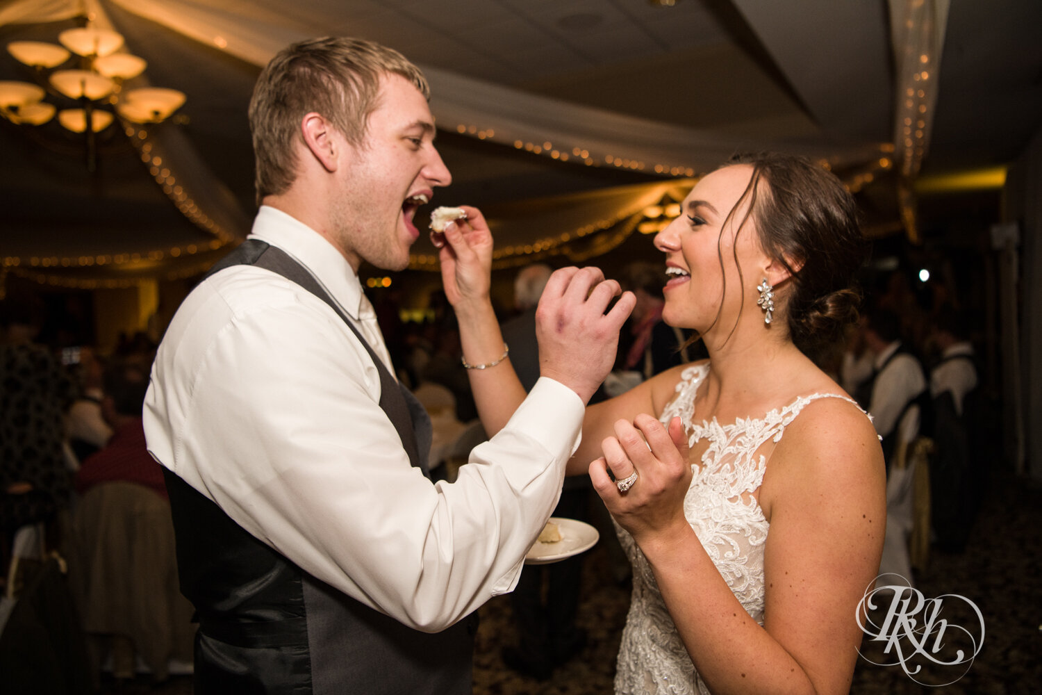 Bride and groom eat cake at wedding reception on rainy day at The Wilds Golf Club in Prior Lake, Minnesota.