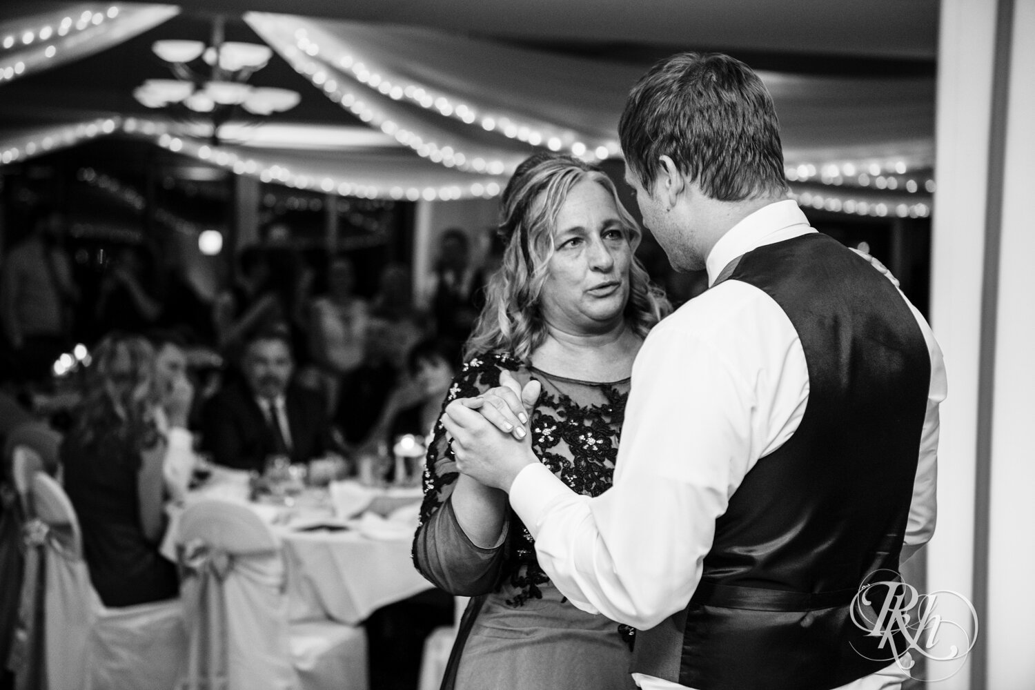 Mom and groom dance at wedding reception on rainy day at The Wilds Golf Club in Prior Lake, Minnesota.