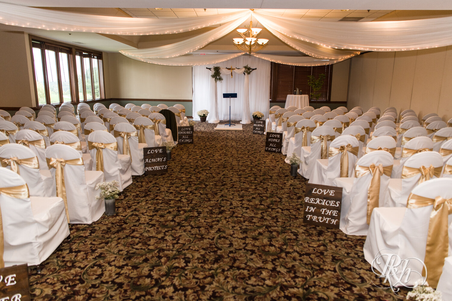 Indoor wedding ceremony with covered chairs