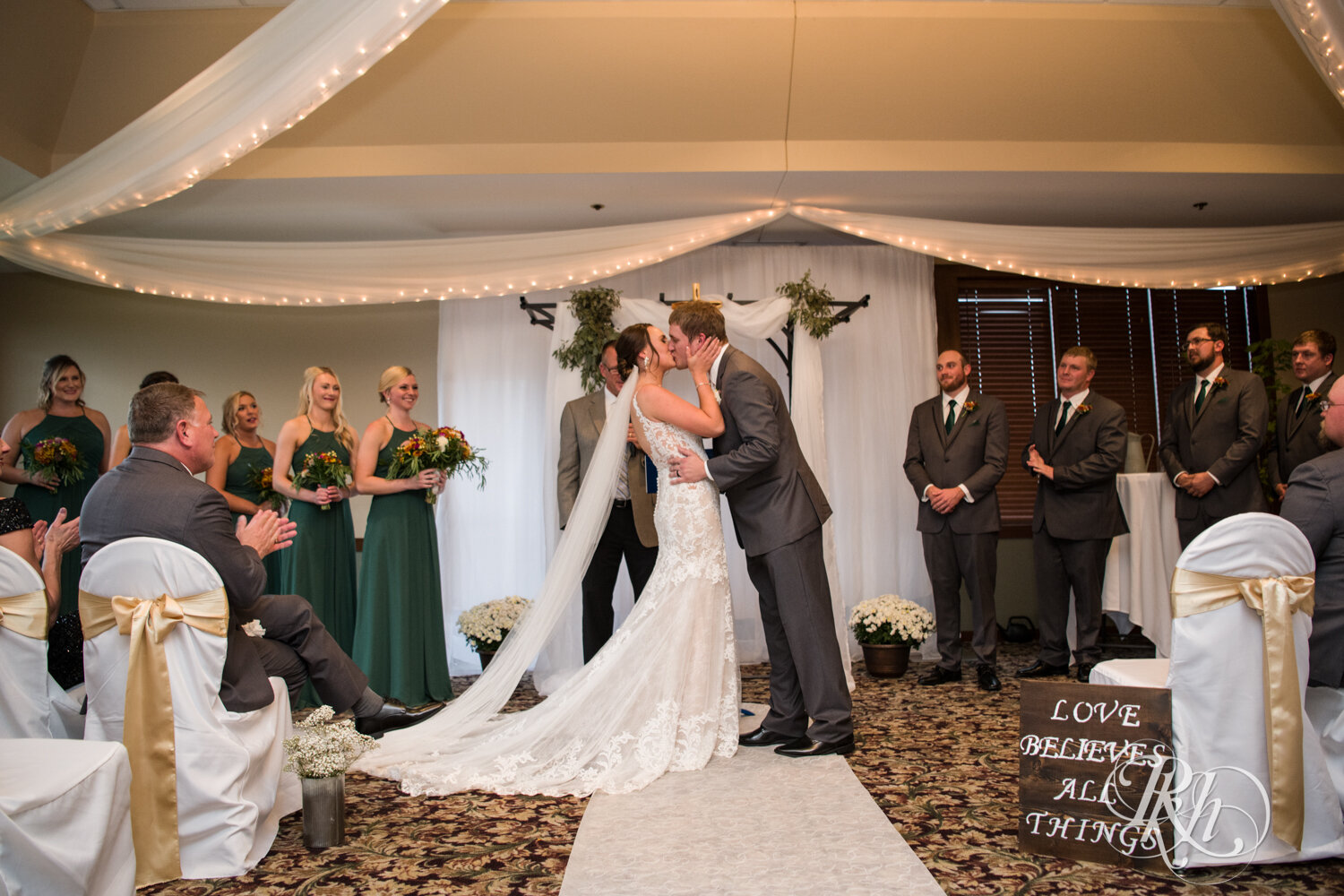 Bride and groom kiss during wedding ceremony at The Wilds Golf Club in Prior Lake, Minnesota.