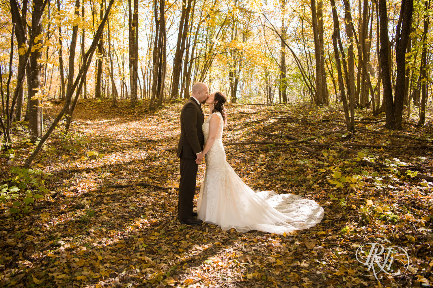 Bride and groom kiss in woods at Minnesota Horse and Hunt Club in Prior Lake, Minnesota.