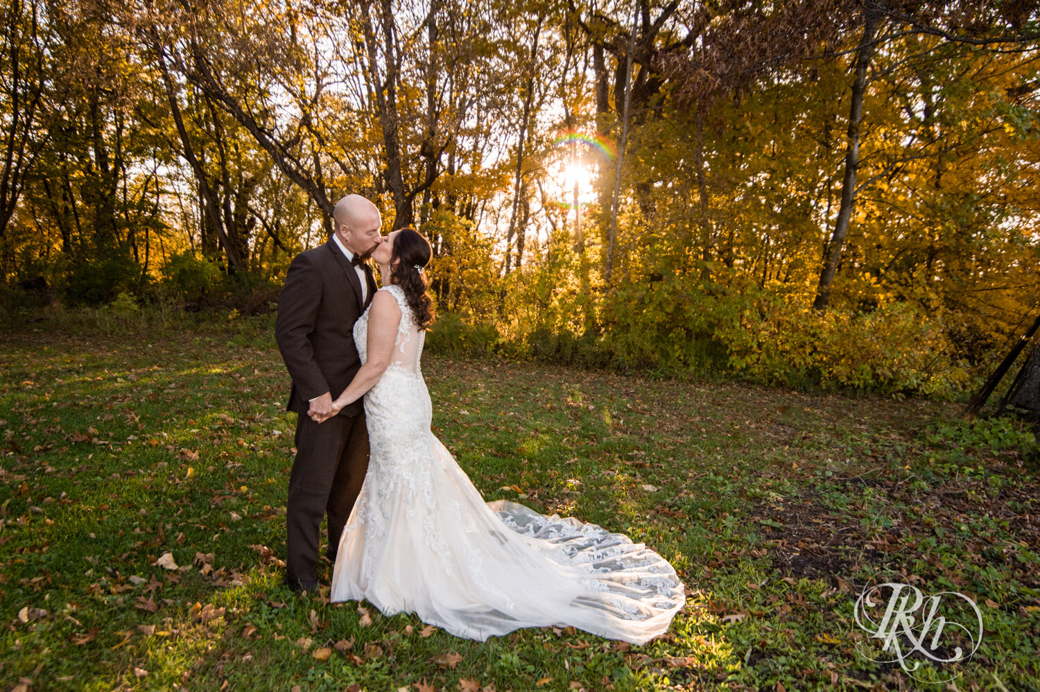 Bride and groom kiss in woods with fall colors at Minnesota Horse and Hunt Club in Prior Lake, Minnesota.
