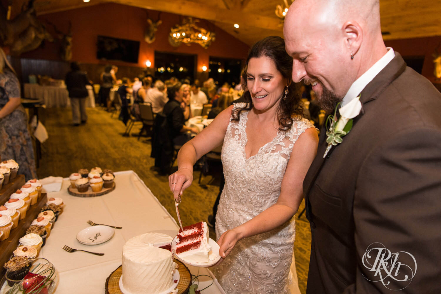 Bride and groom cut cake at wedding reception at Minnesota Horse and Hunt Club in Prior Lake, Minnesota.