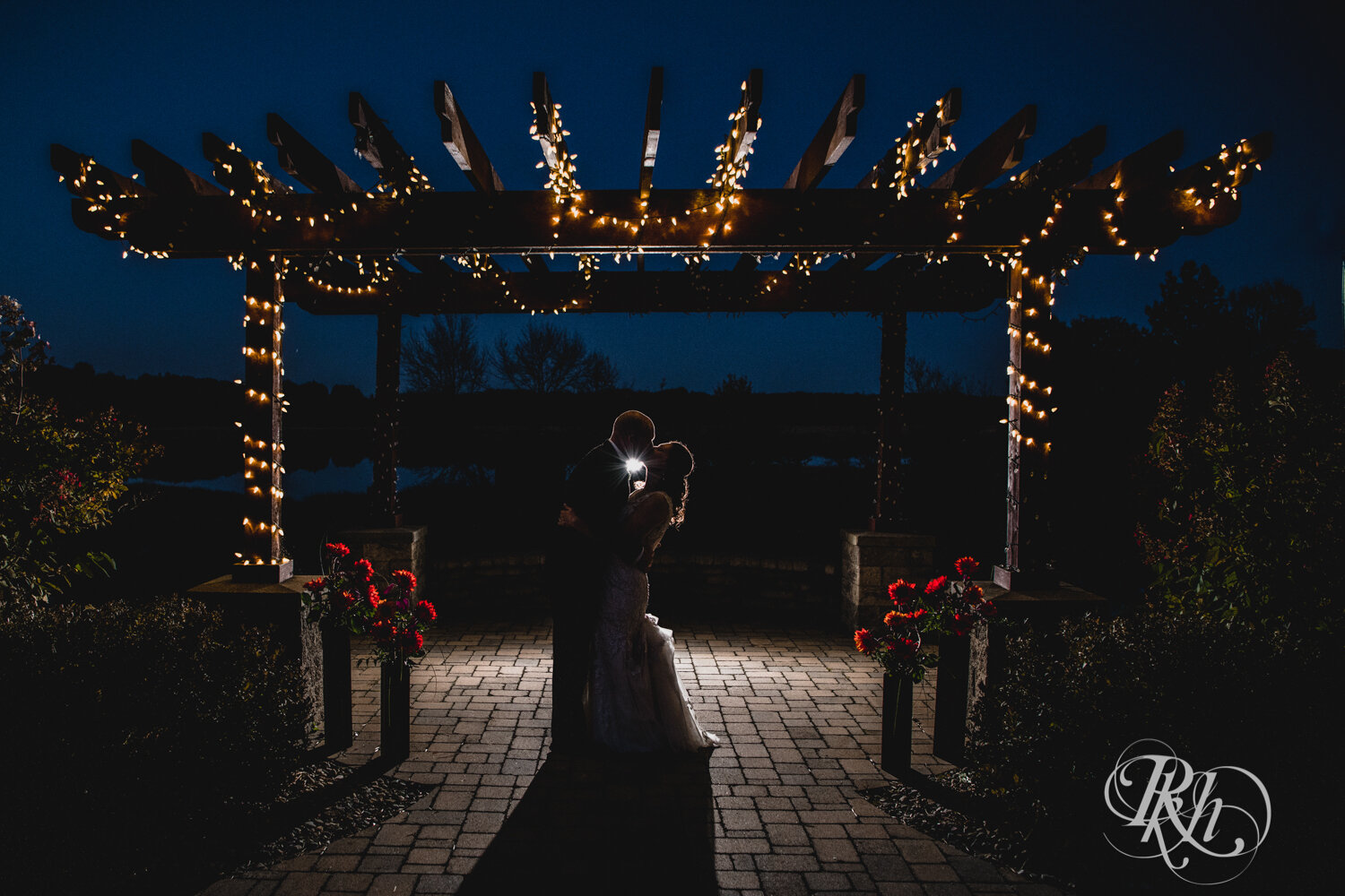 Bride and groom kiss at night at Minnesota Horse and Hunt Club in Prior Lake, Minnesota.