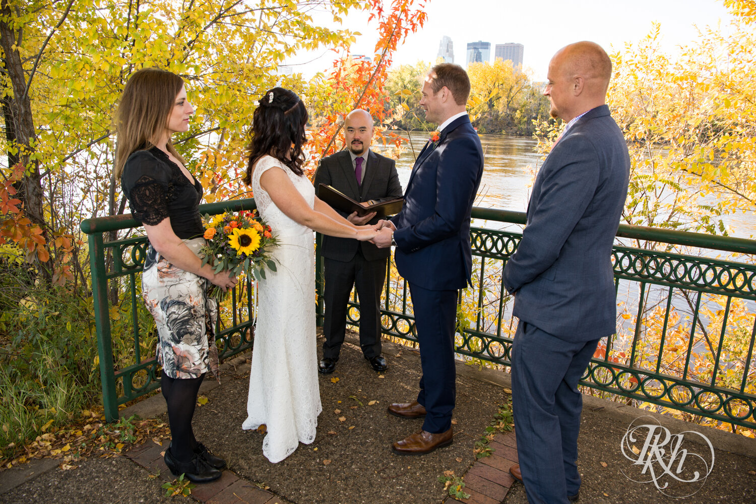 Bride and groom have wedding ceremony on Boom Island in Minneapolis, Minnesota.