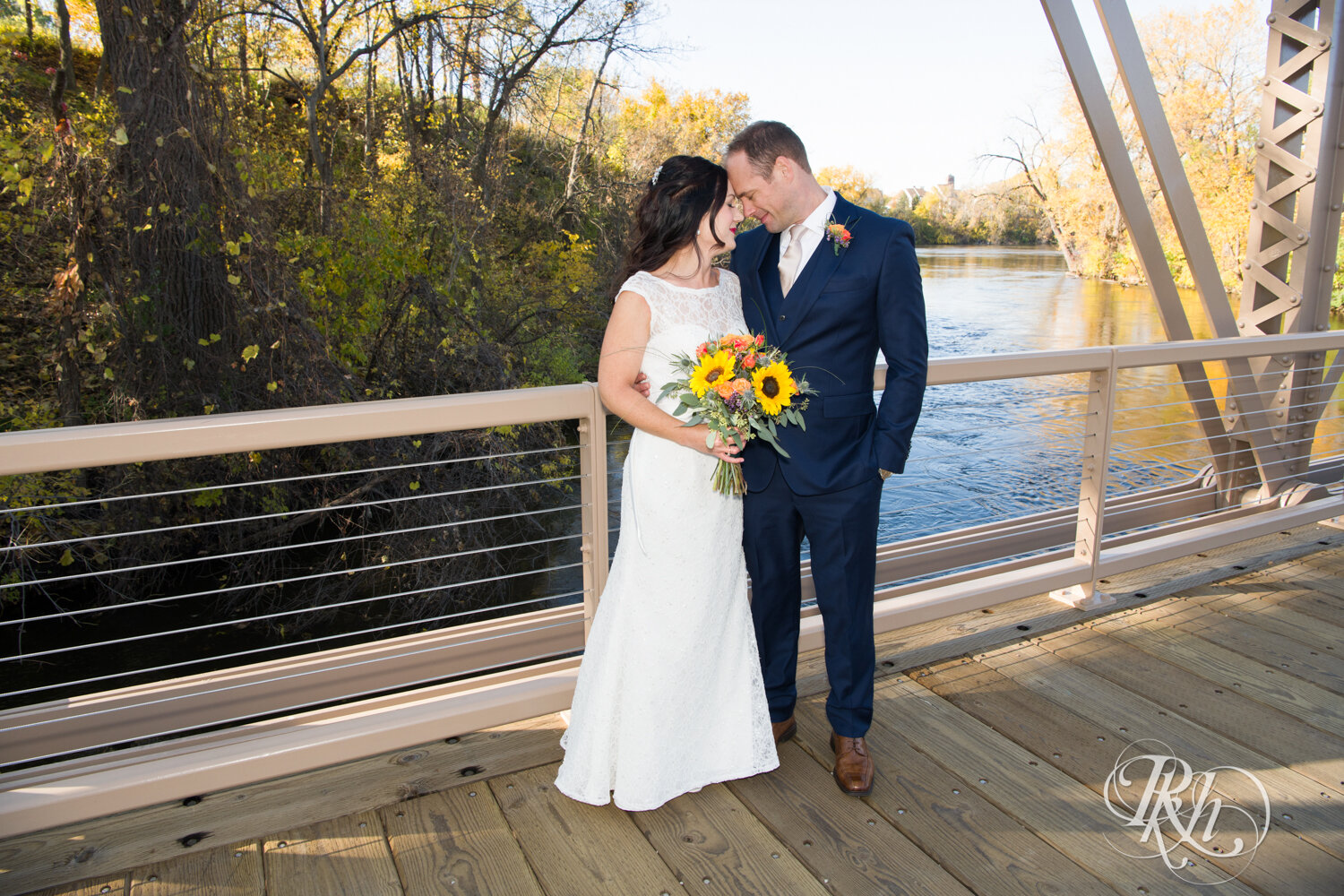 Bride and groom smile on bridge on Boom Island in Minneapolis, Minnesota.