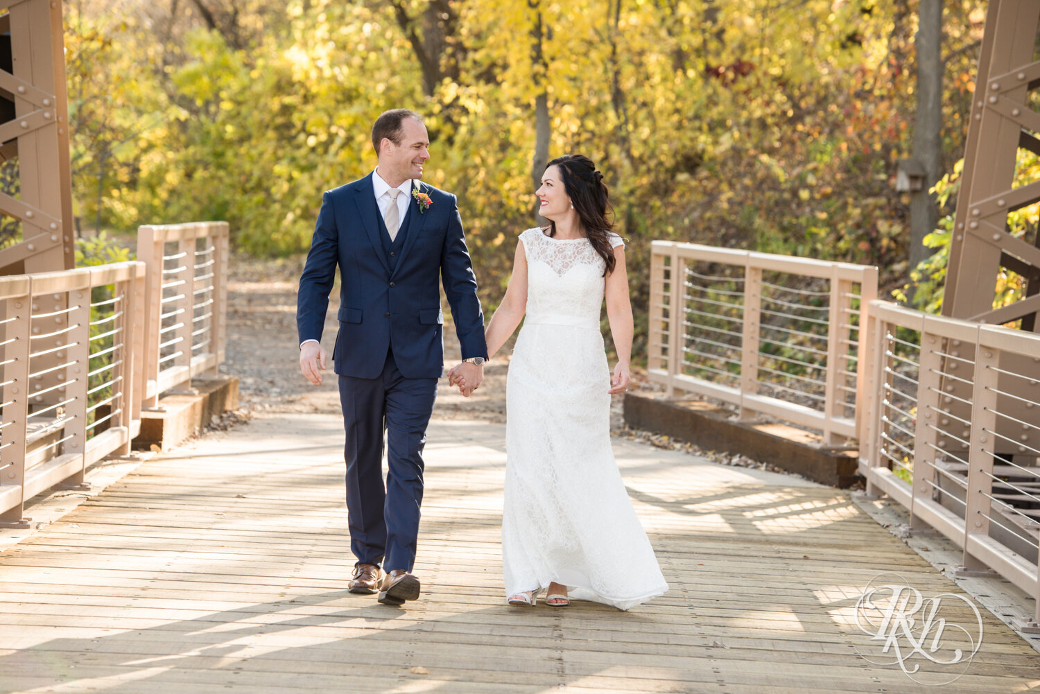 Bride and groom walking on bridge