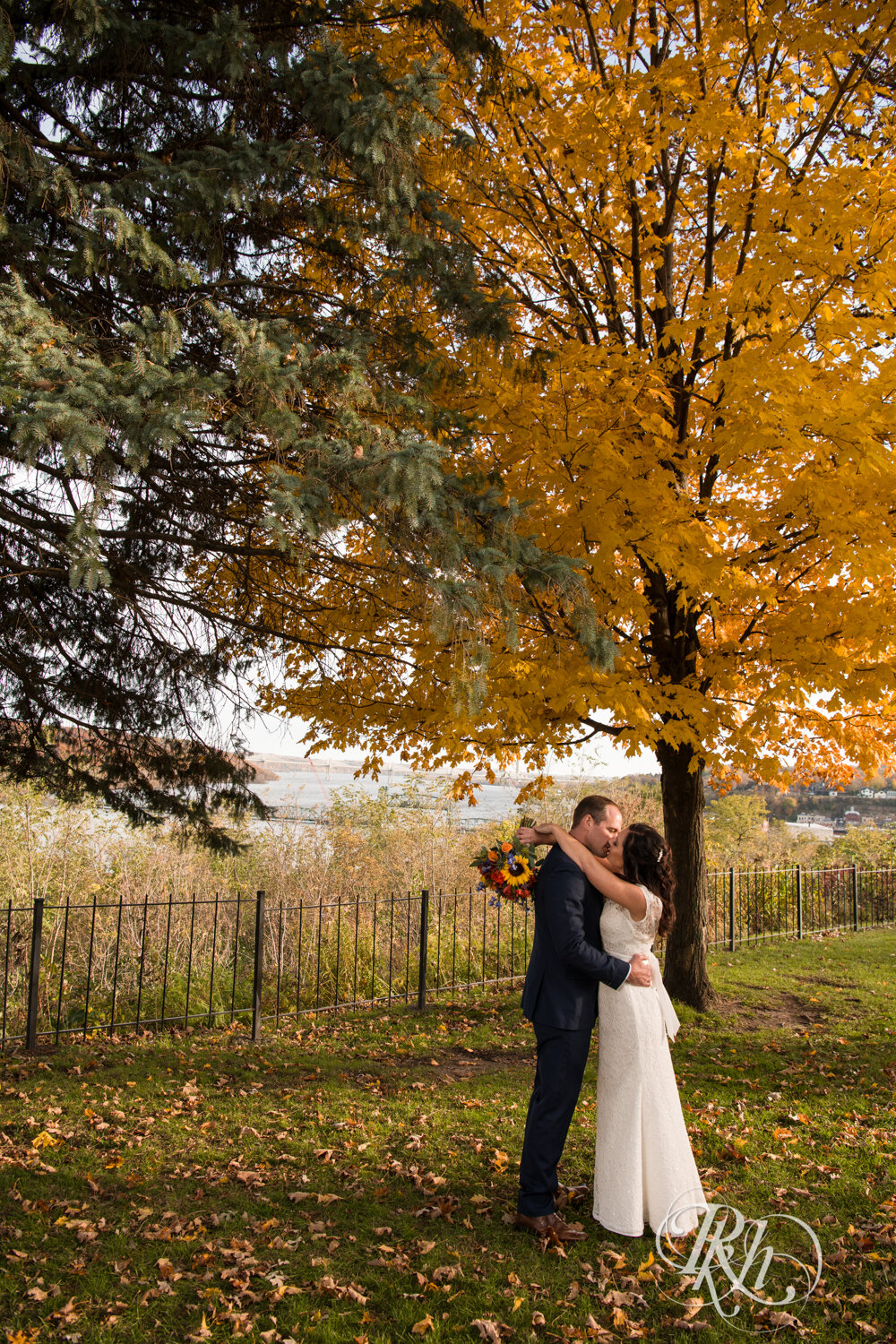 Bride and groom kiss in Pioneer Park in Stillwater, Minnesota at sunset.