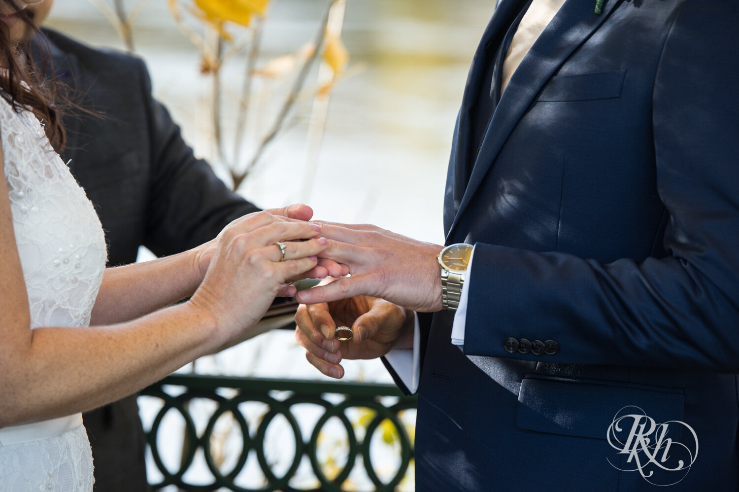 Bride and groom exchange rings at wedding ceremony on Boom Island in Minneapolis, Minnesota.