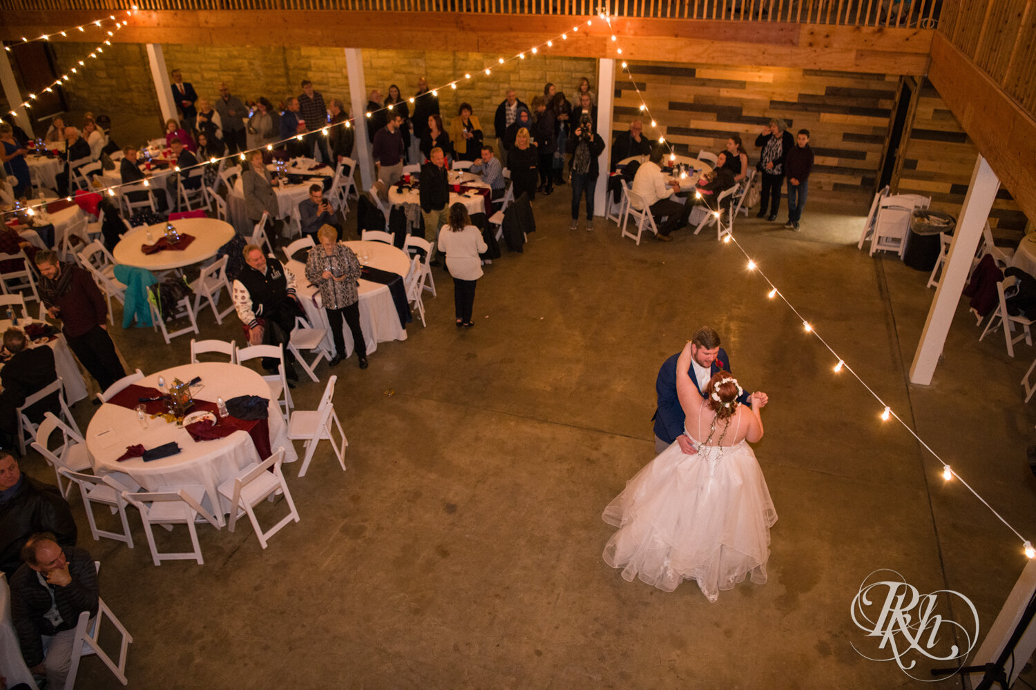 Plus size bride and groom dance at wedding reception at Olmsted County Fairgrounds in Rochester, Minnesota.