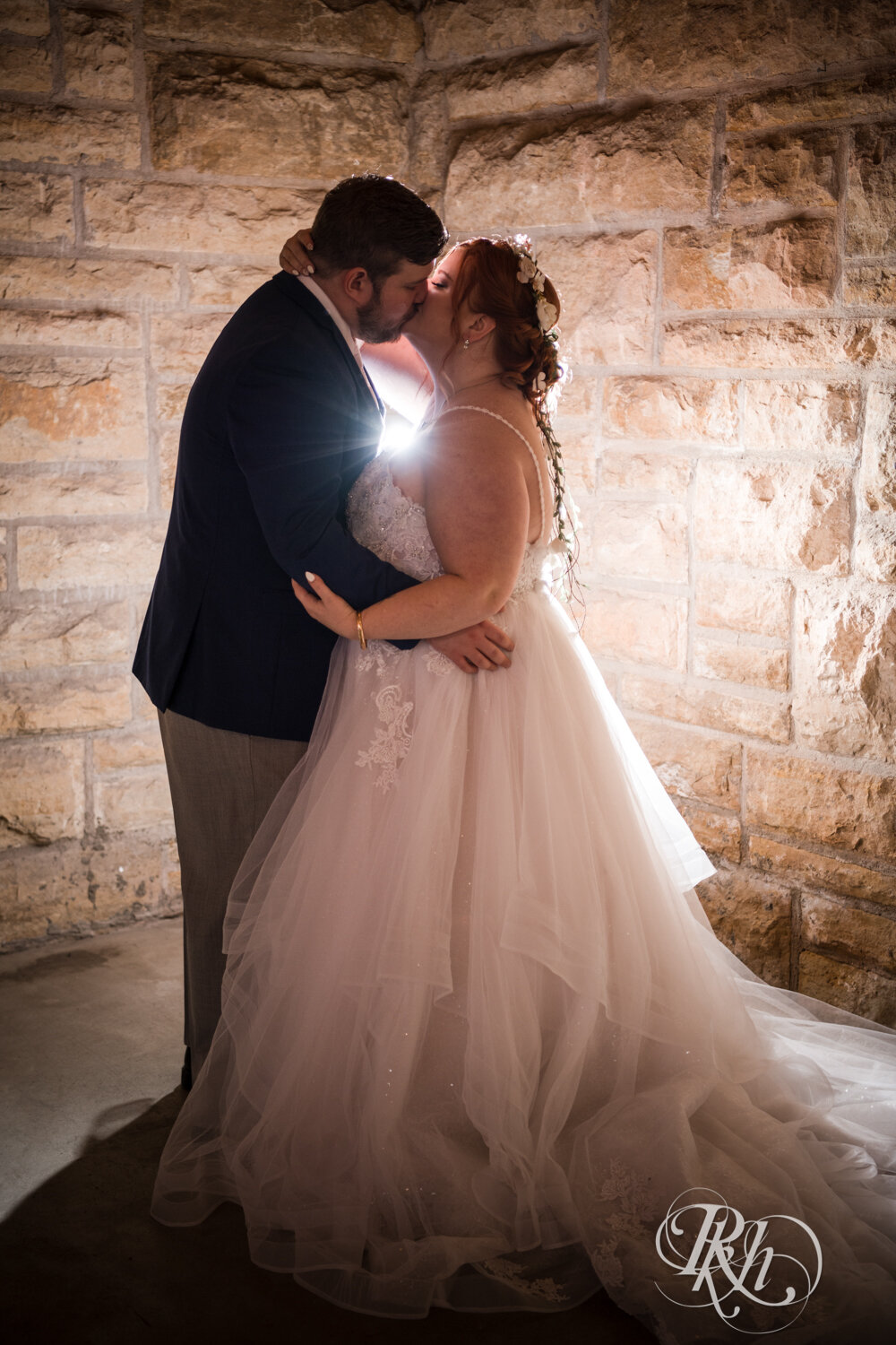 Plus size bride and groom kiss at wedding at Olmsted County Fairgrounds in Rochester, Minnesota.
