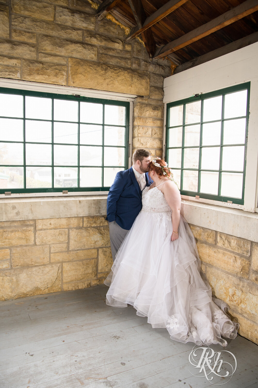 Plus size bride and groom kiss at wedding at Olmsted County Fairgrounds in Rochester, Minnesota.