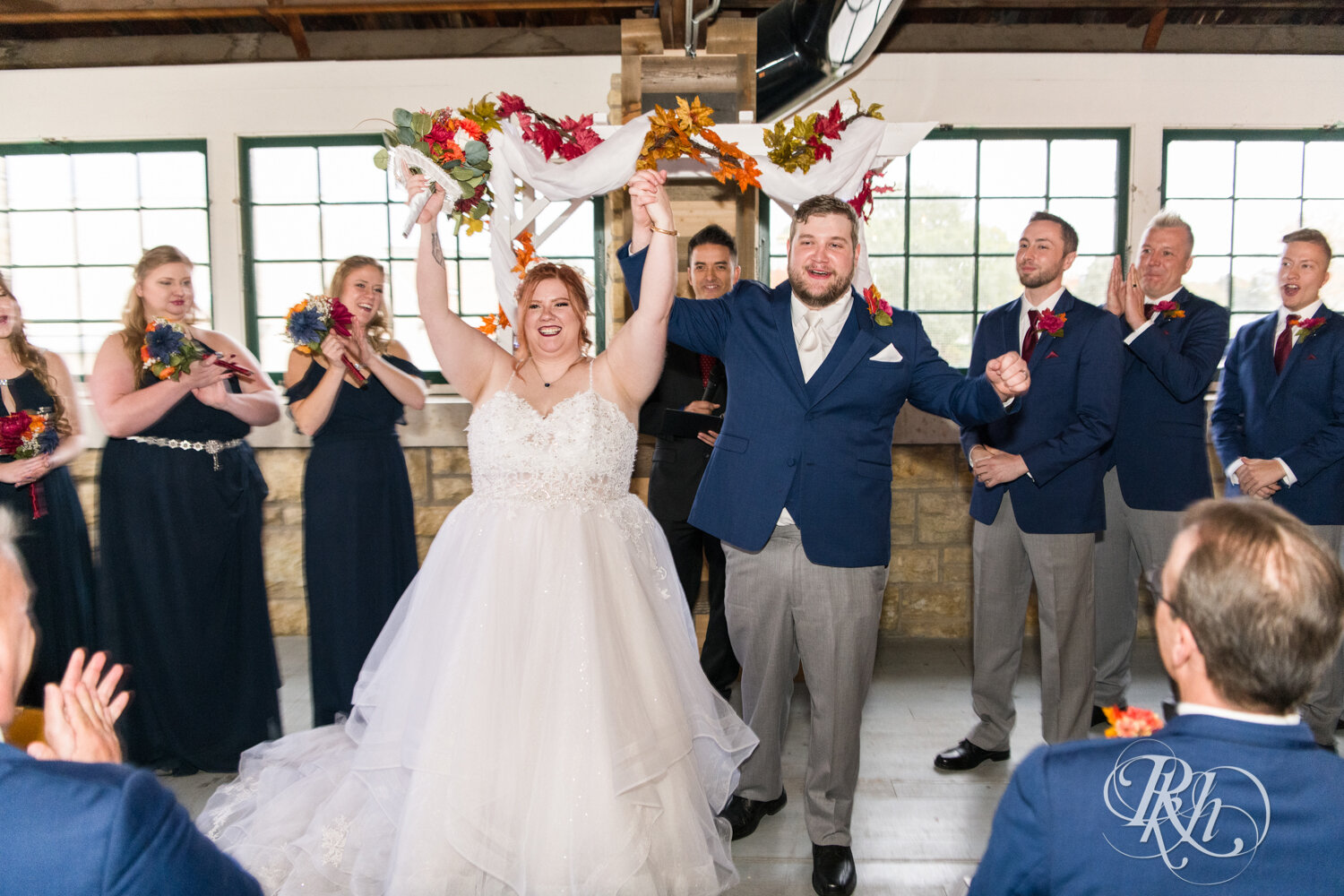 Plus size bride and groom cheer at wedding ceremony at Olmsted County Fairgrounds in Rochester, Minnesota.