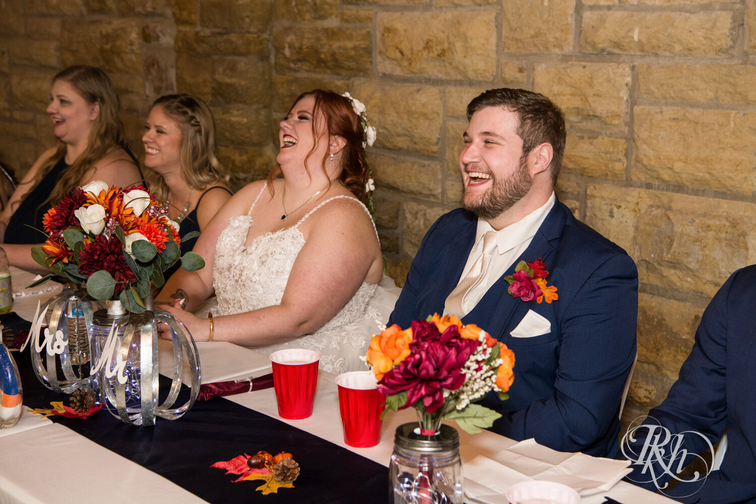 Plus size bride and groom laugh at wedding reception at Olmsted County Fairgrounds in Rochester, Minnesota.