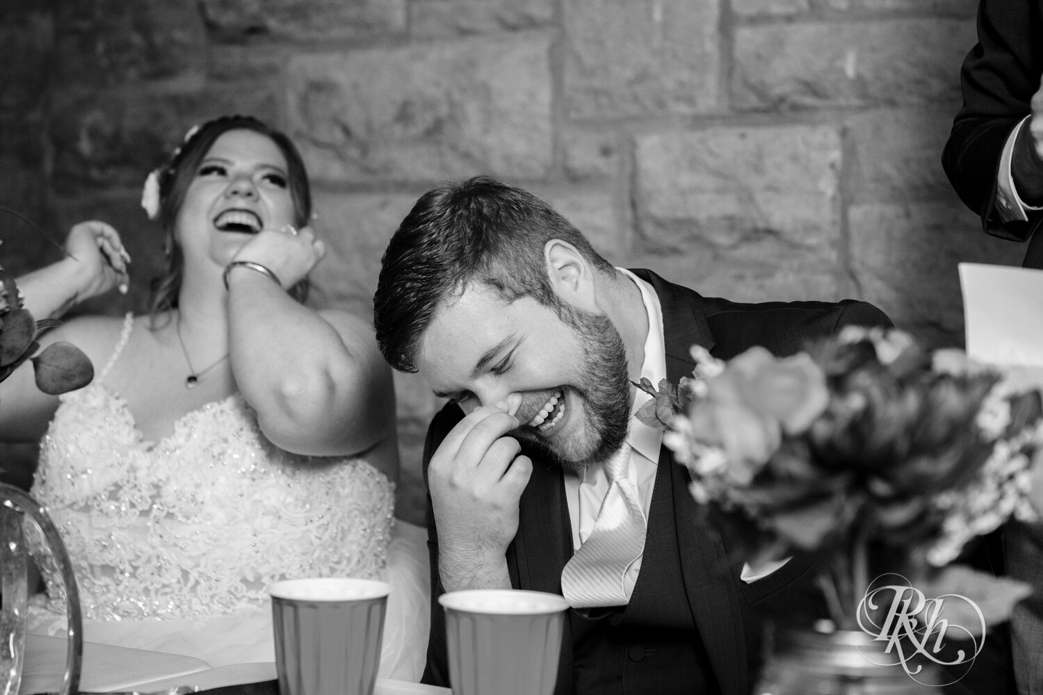 Plus size bride and groom laugh at wedding reception at Olmsted County Fairgrounds in Rochester, Minnesota.