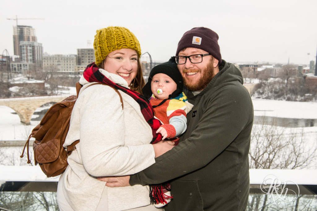Family holding baby dressed in winter clothes