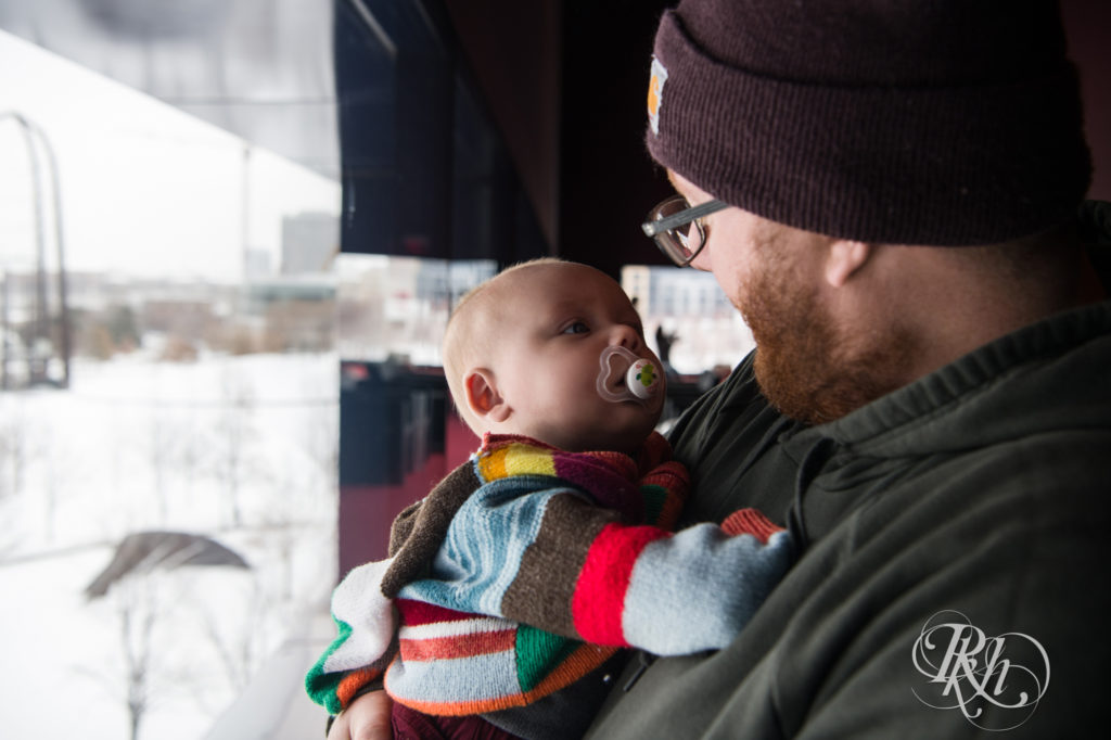Baby looking at father in winter hat