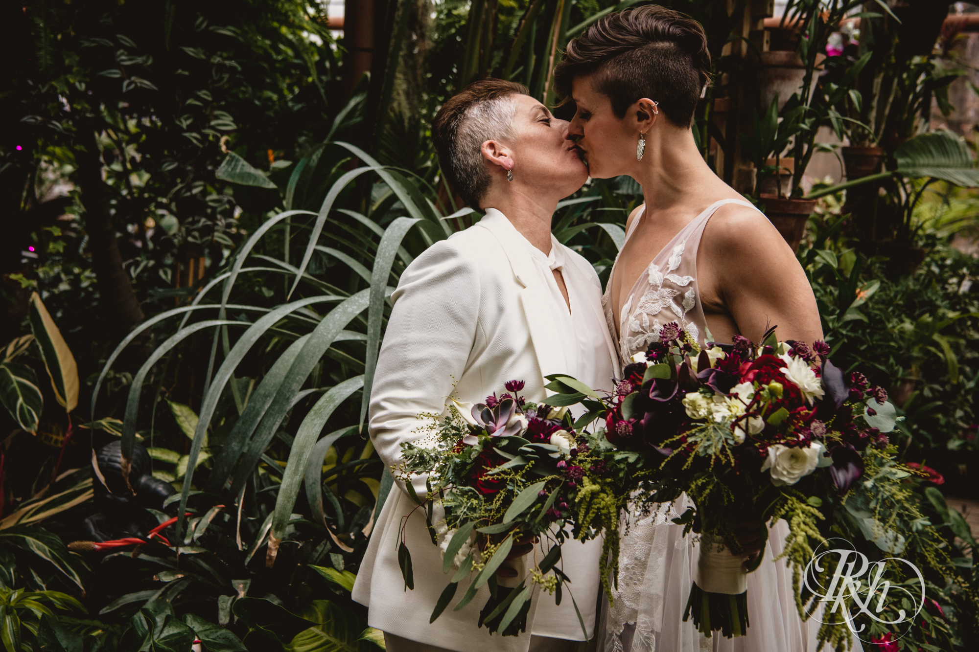 Two brides kissing at an LGBTQ wedding at the Minnesota Landscape Arboretum in Minnesota.