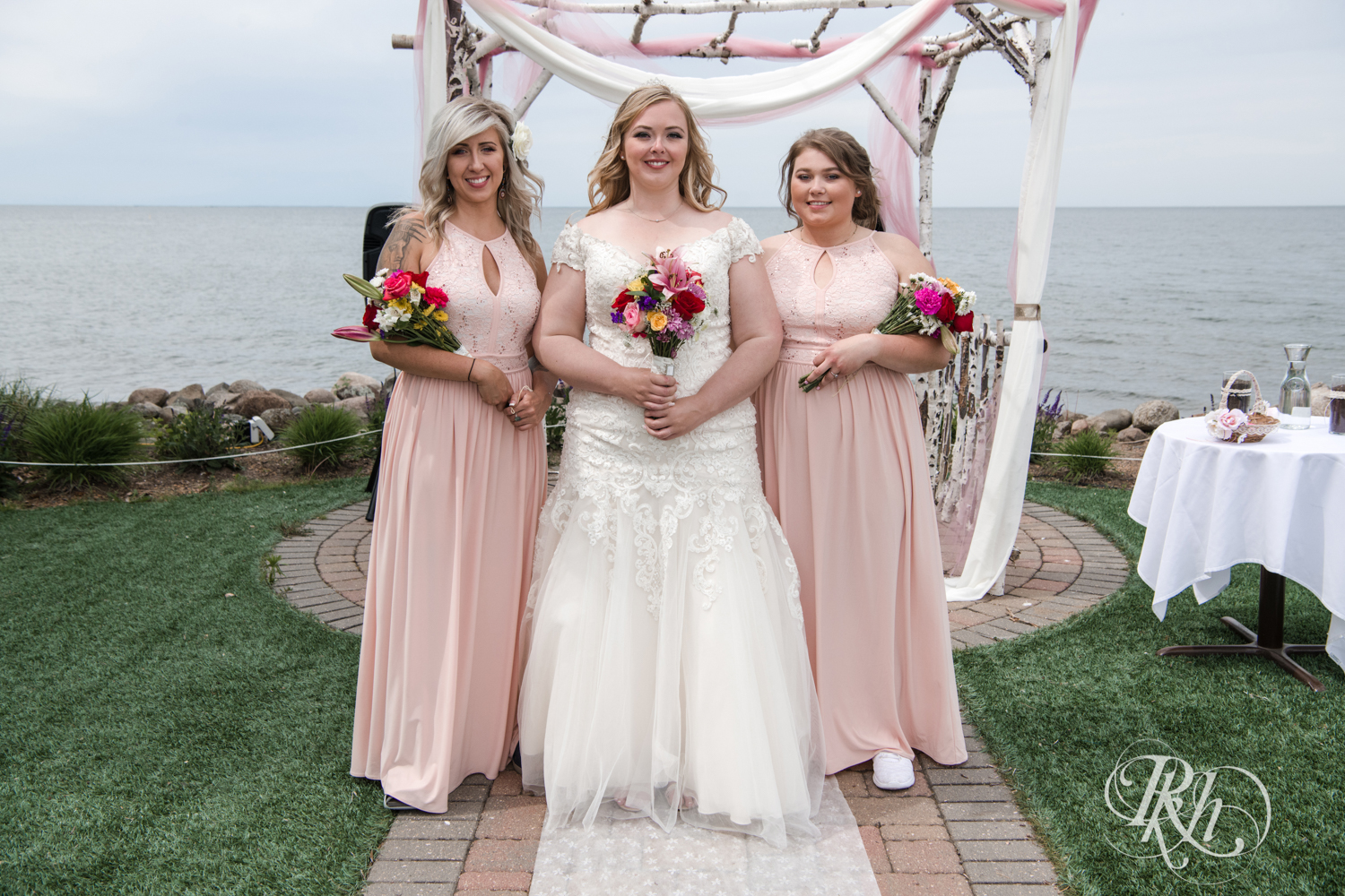 Wedding party smile in front of Lake Mille Lacs at Izatys Resort in Onamia, Minnesota.