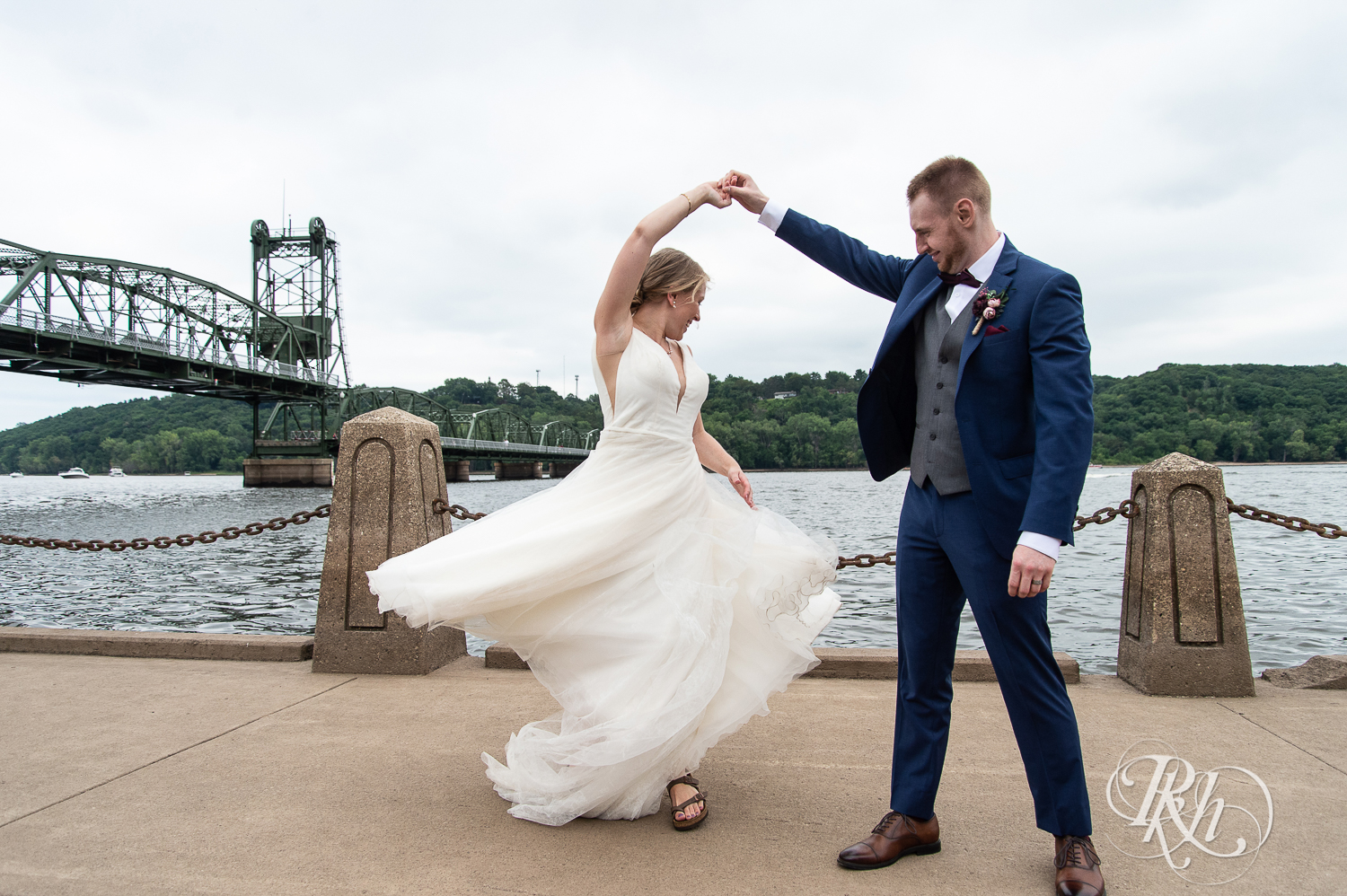 Bride and groom dance in front of St. Croix River in Stillwater, Minnesota.