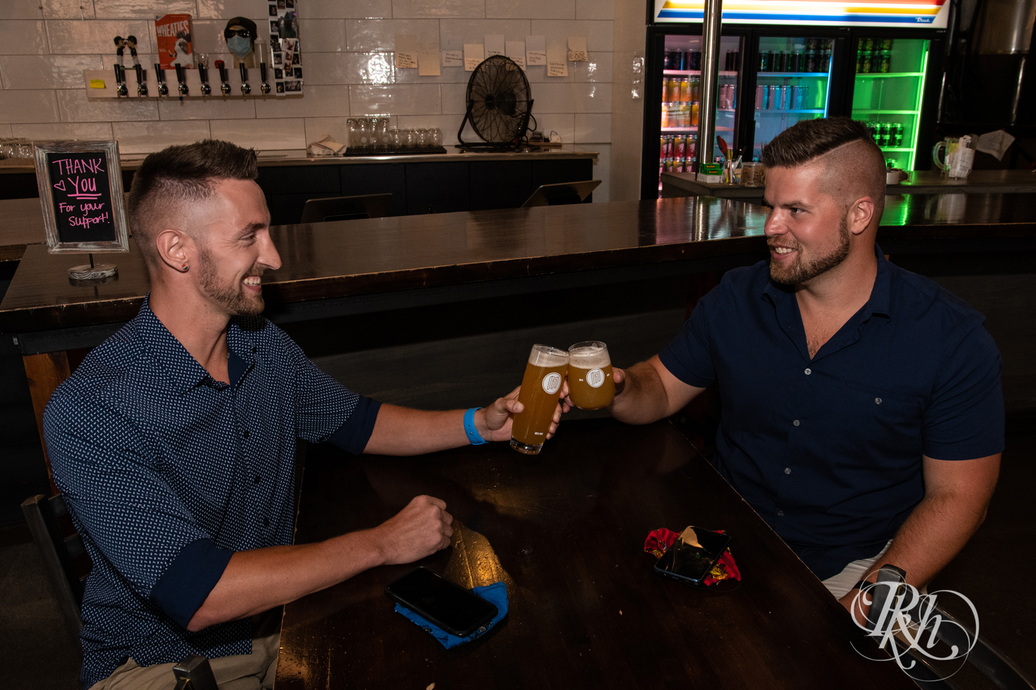 Two men toast their engagement at Modist Brewing in Minneapolis, Minnesota.