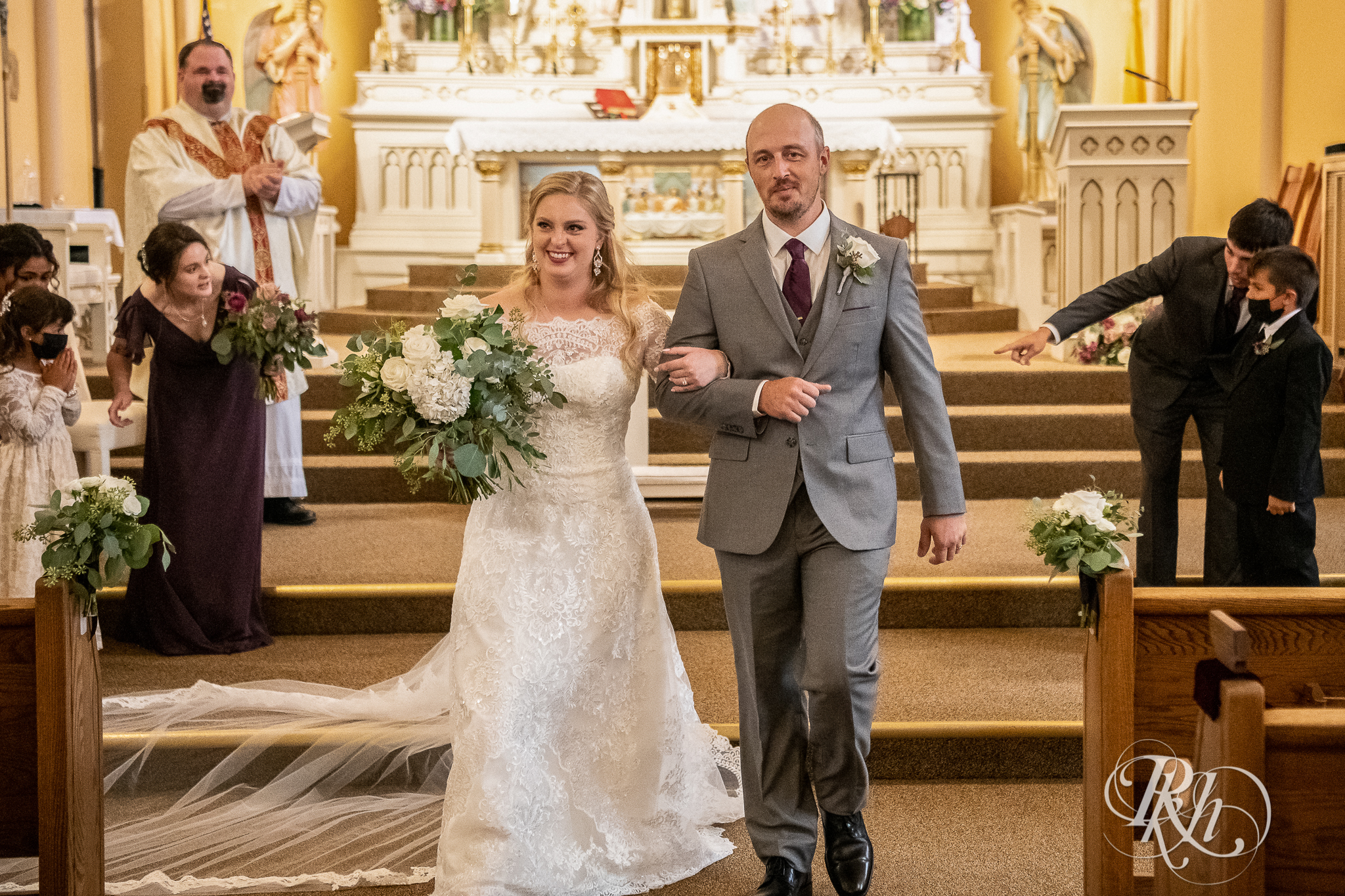 Bride and groom walk down the aisle after ceremony at church wedding in New Prague, Minnesota.
