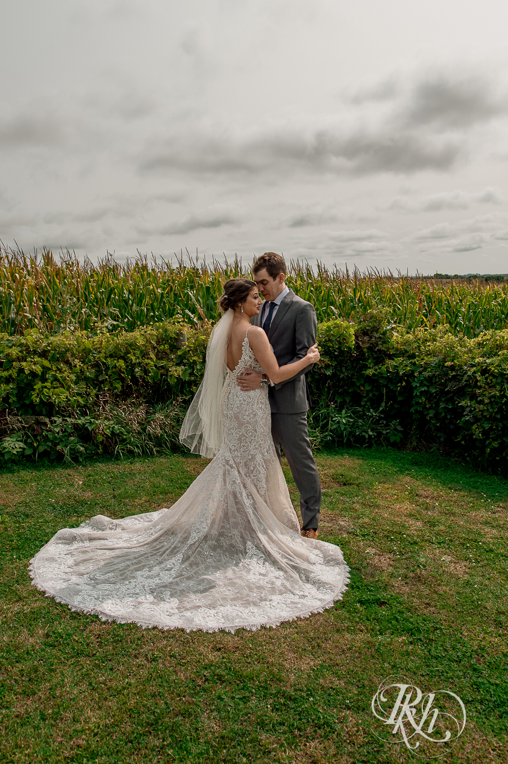 Bride and groom kiss in front of cornfield at Legacy Hills Farm in Welch, Minnesota.