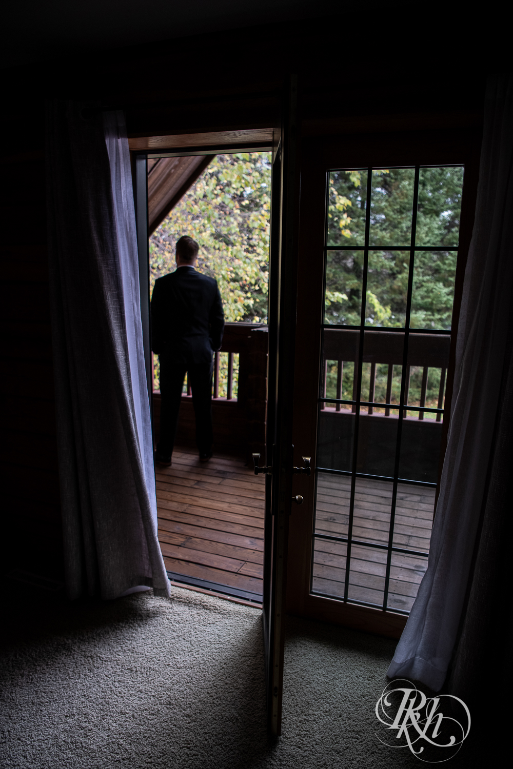 Bride and groom share first look on balcony at a cabin A-frame in Stillwater, Minnesota.