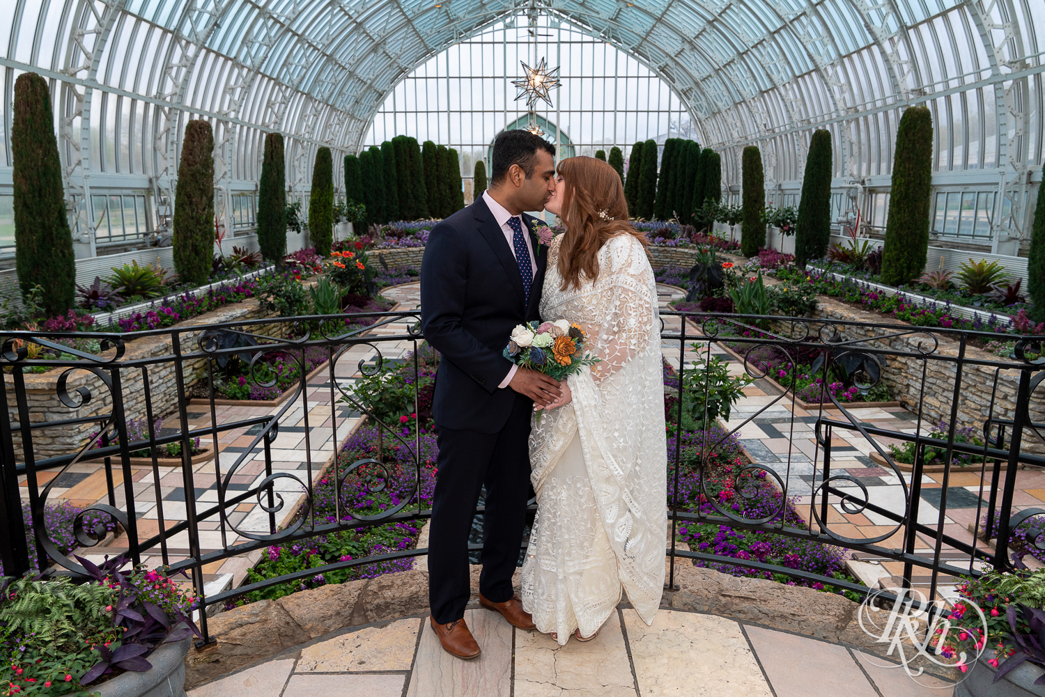 Bride and groom kiss at Indian wedding at Como Zoo Conservatory in Saint Paul, Minnesota.
