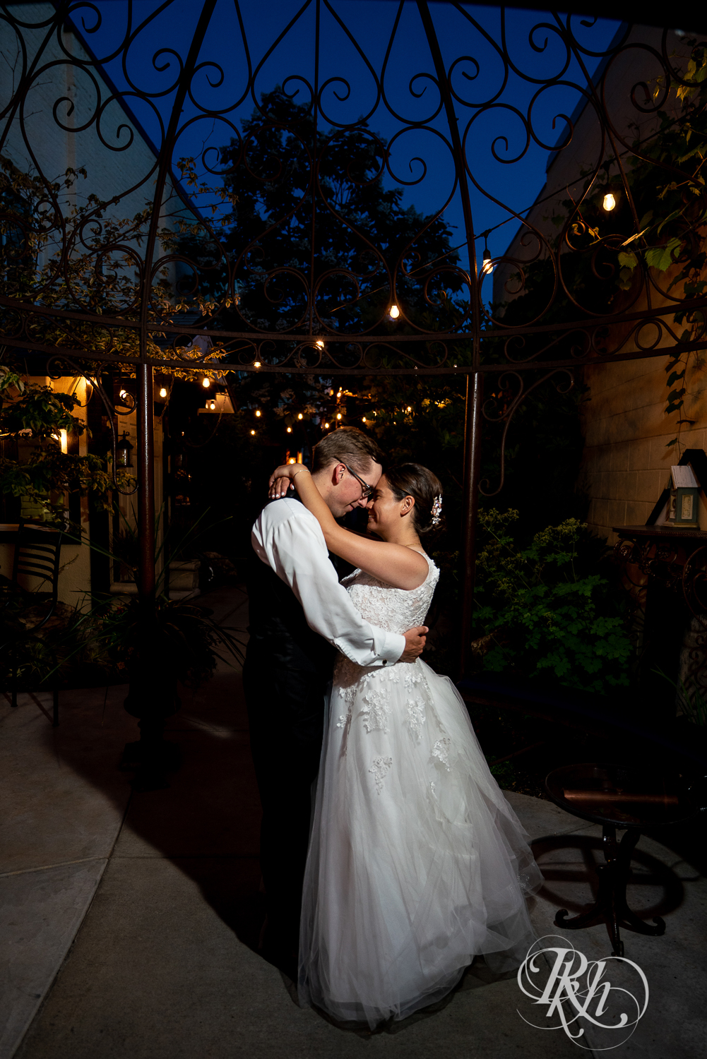 Bride and groom kiss outside at night at Kellerman's Event Center in White Bear Lake, Minnesota.