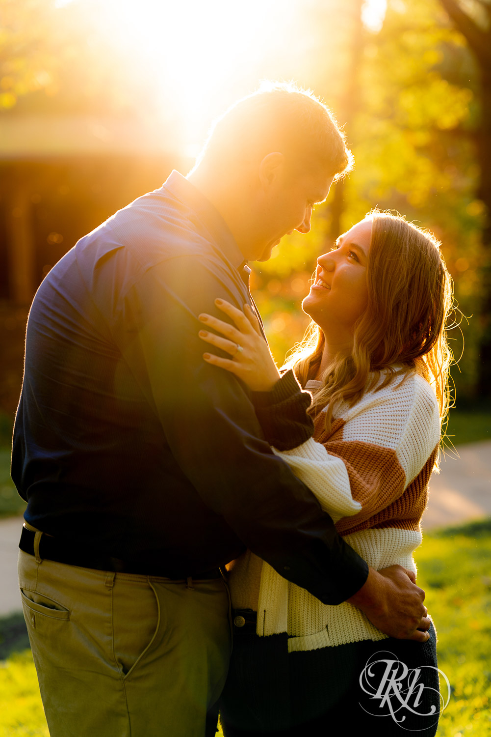 Man and woman smiling during sunset engagement photo session at Lebanon Hills Regional Park in Eagan, Minnesota.