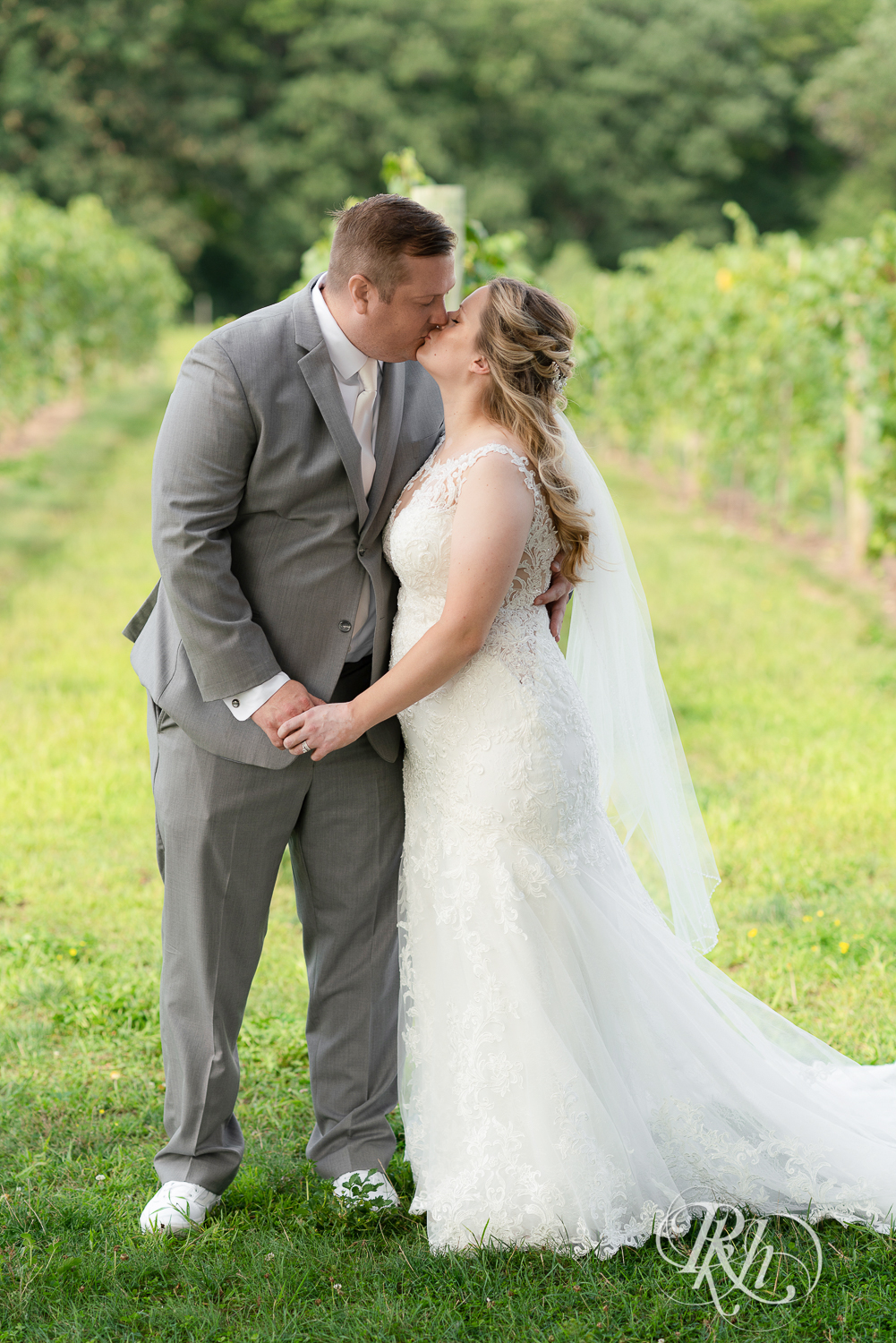 Bride and groom kissing at summer wedding at 7 Vines Vineyard in Dellwood, Minnesota.