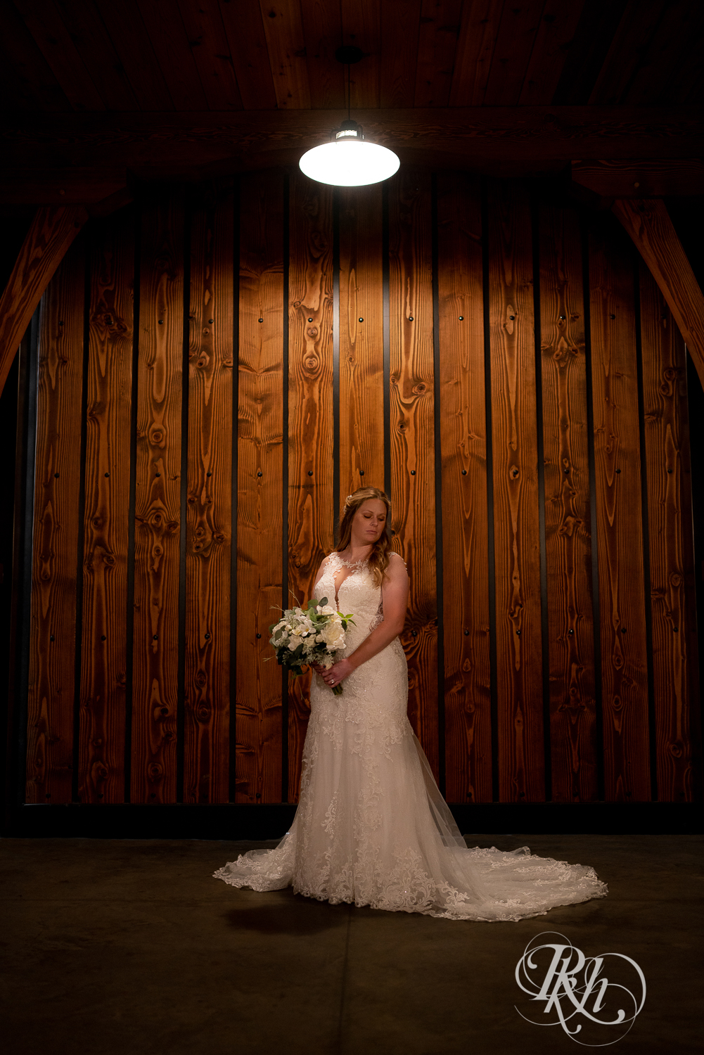 Bride holding flowers under light at 7 Vines Vineyard in Dellwood, Minnesota.