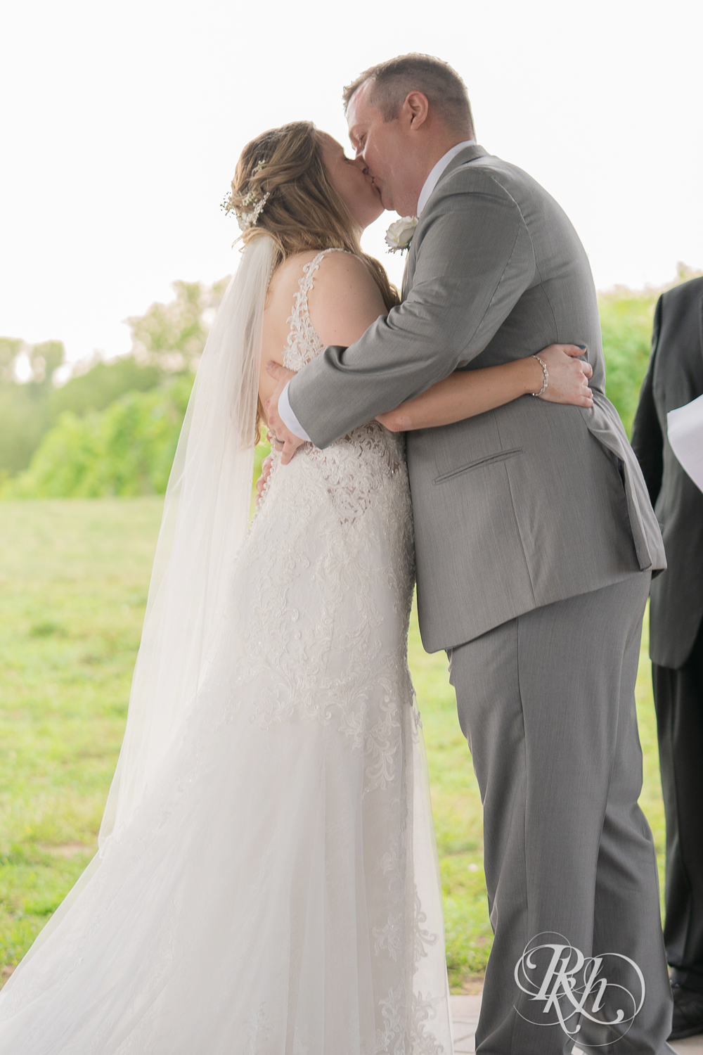 Bride and groom kiss at alter during wedding ceremony at 7 Vines Vineyard in Dellwood, Minnesota.