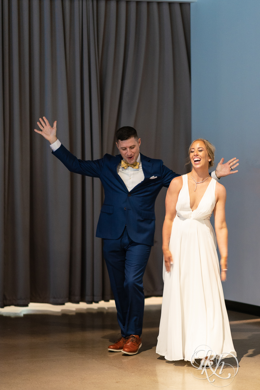 Bride and groom dance in during grand entrance at Saint Paul Event Center in Saint Paul, Minnesota.