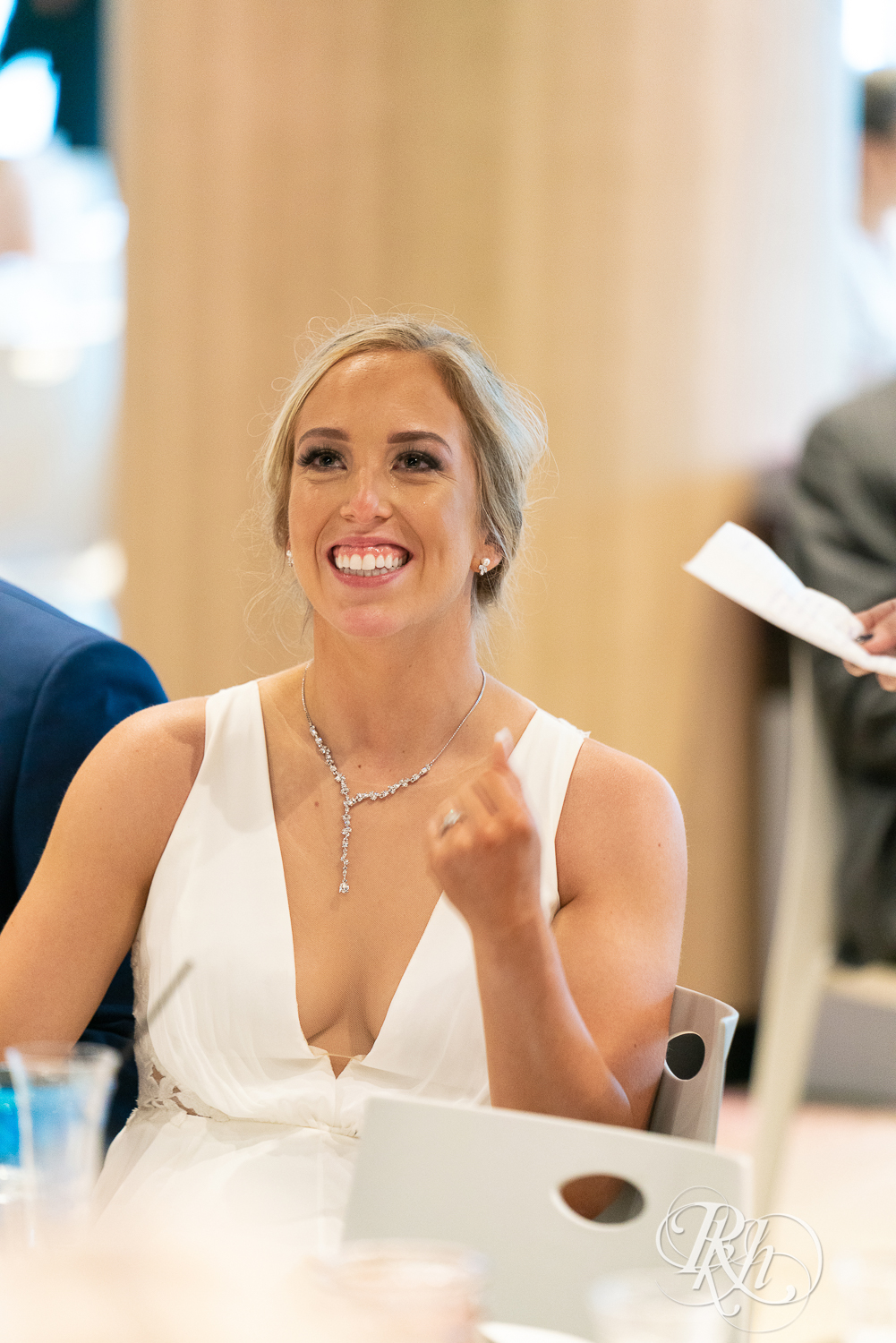 Bride smiling during wedding reception at head table at Saint Paul Event Center in Saint Paul, Minnesota.