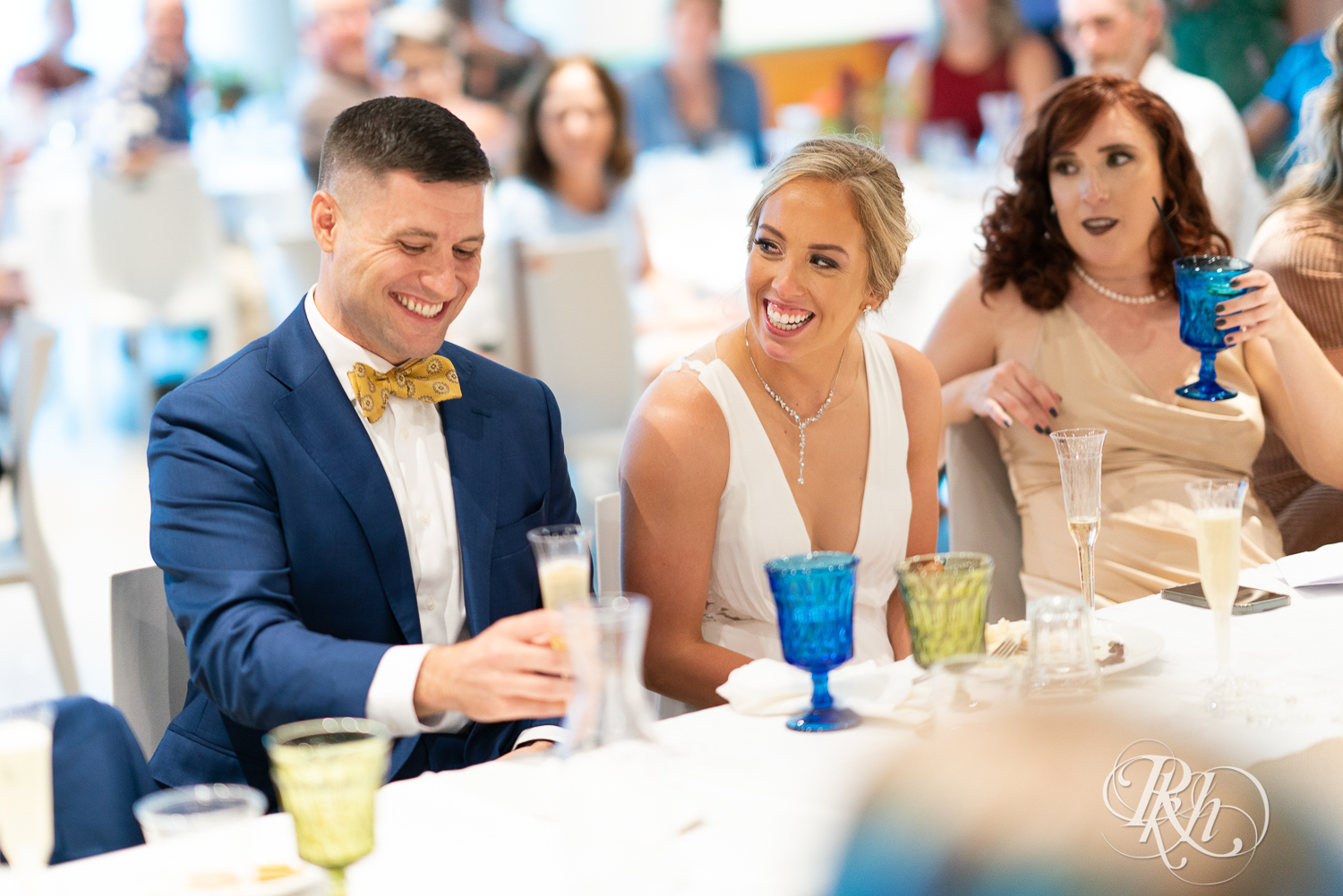 Bride and groom smiling during wedding reception at head table at Saint Paul Event Center in Saint Paul, Minnesota.