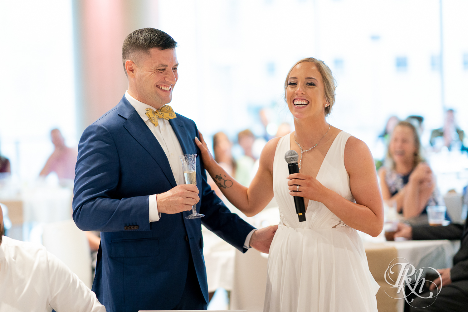 Bride and groom laughing during speeches at reception in Saint Paul, Minnesota.